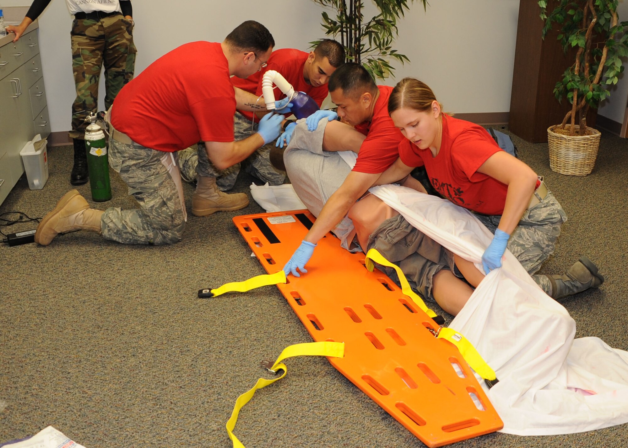 CANNON AIR FORCE BASE, N.M.-- (From left) Tech. Sgt. Aramis Cedeno and Senior Airman Gilberto Maldonado, 27th Special Operations Aerospace Medicine Squadron, provide rescue breathing and maintain head stabilization during the Emergency Medical Technicians Rodeo Oct. 3. Staff Sgt. Ngu Do and Senior Airman Dena Levari, 27th Special Operations Medical Operations Squadron, are accessing the patient for any injuries before lowering the patient to the long back board. (U.S. Air Force photo by Airman 1st Class Maynelinne Y. De La Cruz)