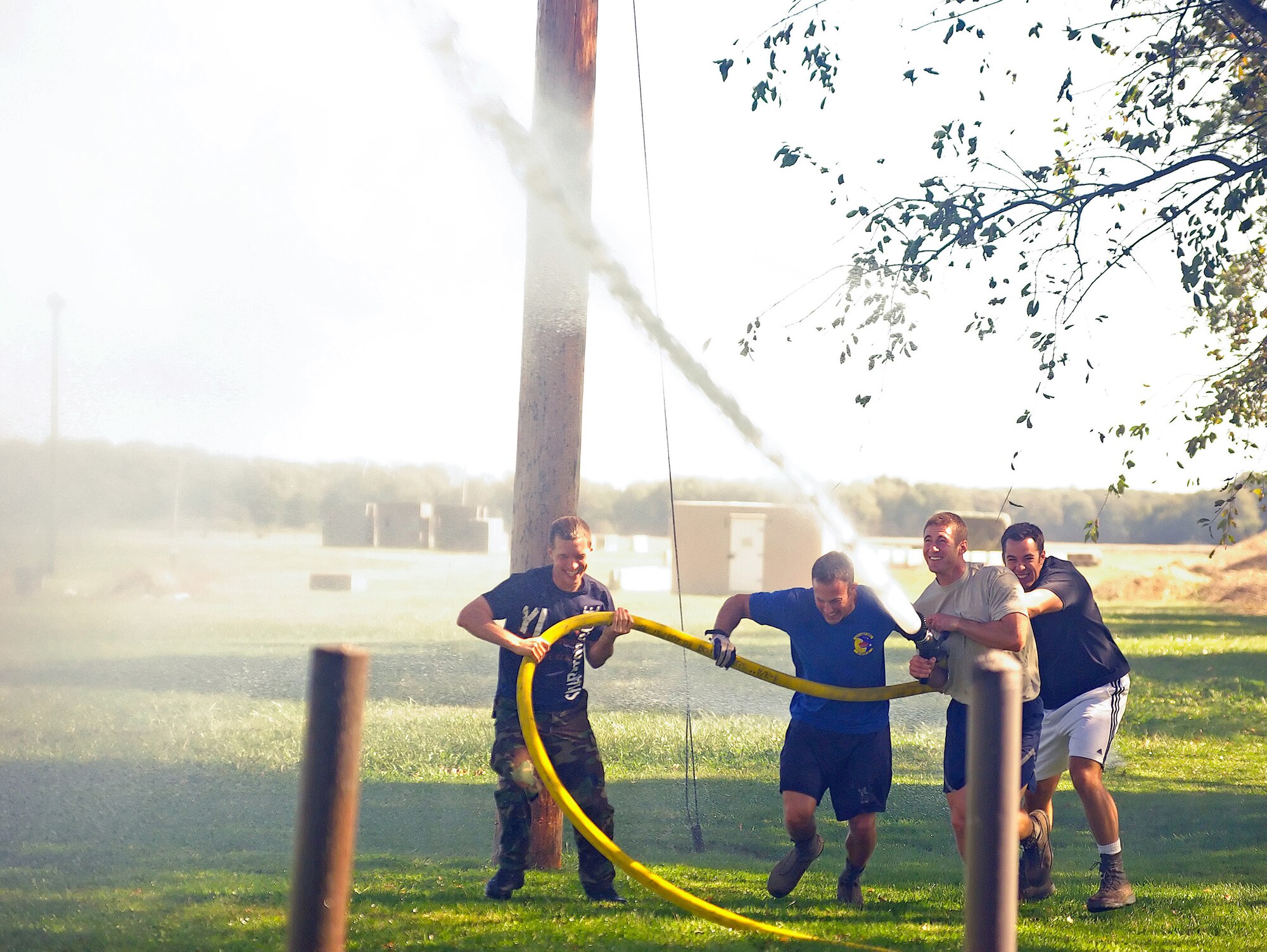 (Left to right) Capt. Matthew Mottet, 3rd Airlift Squadron; Capt. Timothy Kniefel, 3rd AS; Capt. Thomas Petykowski, 3rd AS, and 1st Lt. Michael Busse, 3rd AS, work together to handle a fire hose during the Fire Muster Oct. 9. The Fire Muster was a series of events desgined to exhibit the skills required by fire fighters to perform their duties. (U.S. Air Force photo/April Stover)