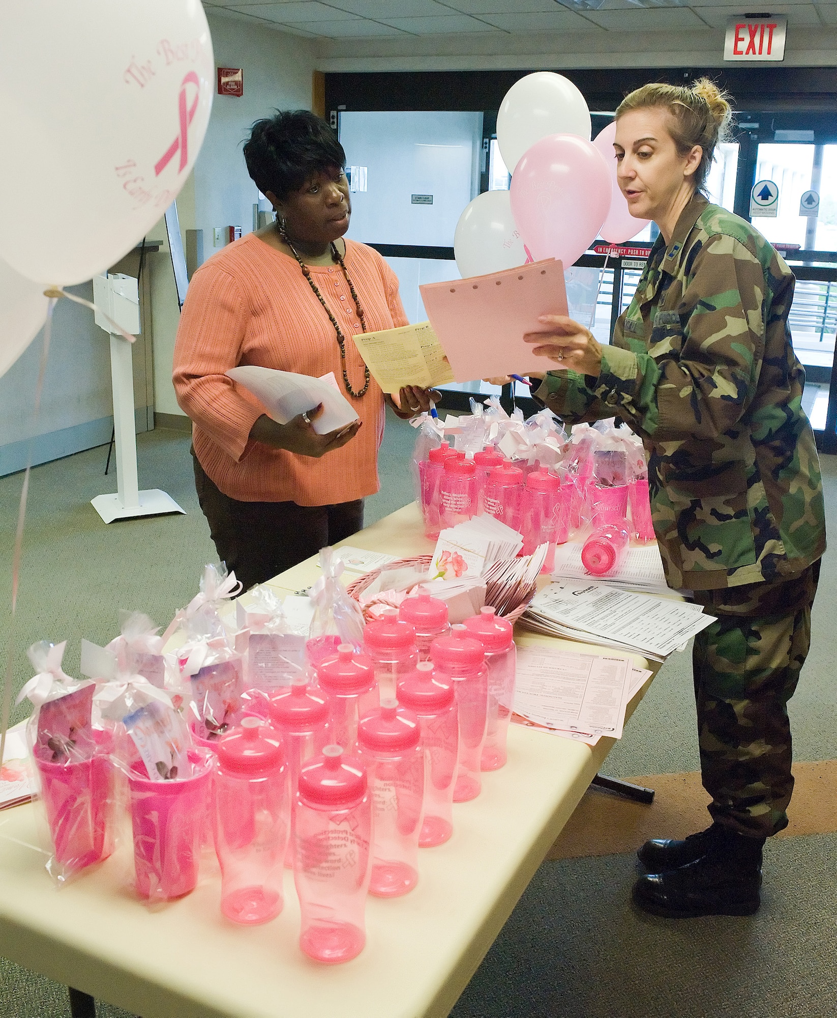 (Left to right) Avonda Johnson, 436th Aerospace Medical Squadron, and Capt. Sherry Stigall, 436th Medical Operations Squadron, set up the breast cancer awareness month information booth Oct. 2 at the 436th Medical Group. The 436th Medical Group is working to increase awareness of breast cancer by encouraging annual mammograms and helping set up appointments for mammograms. (U.S. Air Force photo/Jason Minto)