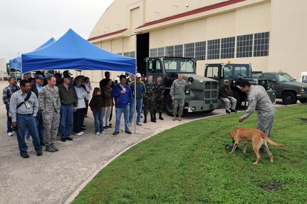 Pilots attending the Randolph Civil Fly-In Oct. 10 take a break and watch a military working dog demonstration by the 12th Security Forces Squadron.  In addition to the dog demo, local aviators were treated to flying safety briefings and presentations by the Federal Aviation Administration, displays from life support, the base fire department, and aerospace physiology. (U.S. Air Force photo/Don Lindsey)