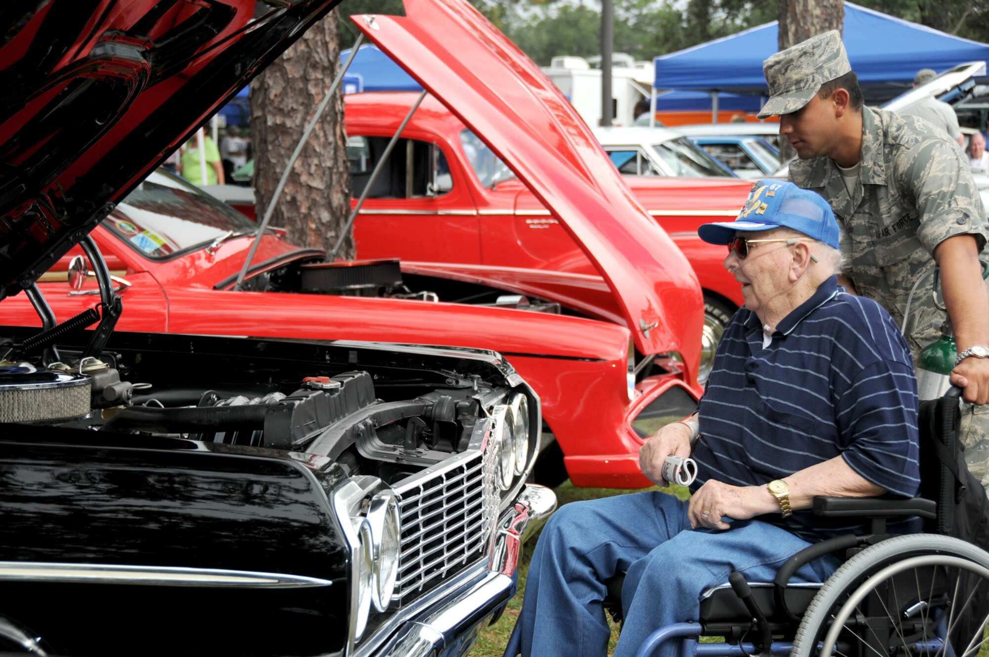 Air Force retiree George Macon and Airman Basic Justin Baez, 334th Training Squadron, admire a 1964 Chevrolet Impala convertible Oct. 6 as Cruisin’ the Coast made a stop at the Biloxi Veterans Affairs Medical Center.  Chaplain (Capt.) Eric Whitmore and 48 students from the 334th and 338th TRS assisted VA residents in viewing the vintage automobiles during their annual week-long gathering on the Mississippi Gulf Coast.  (U.S. Air Force photo by Kemberly Groue)