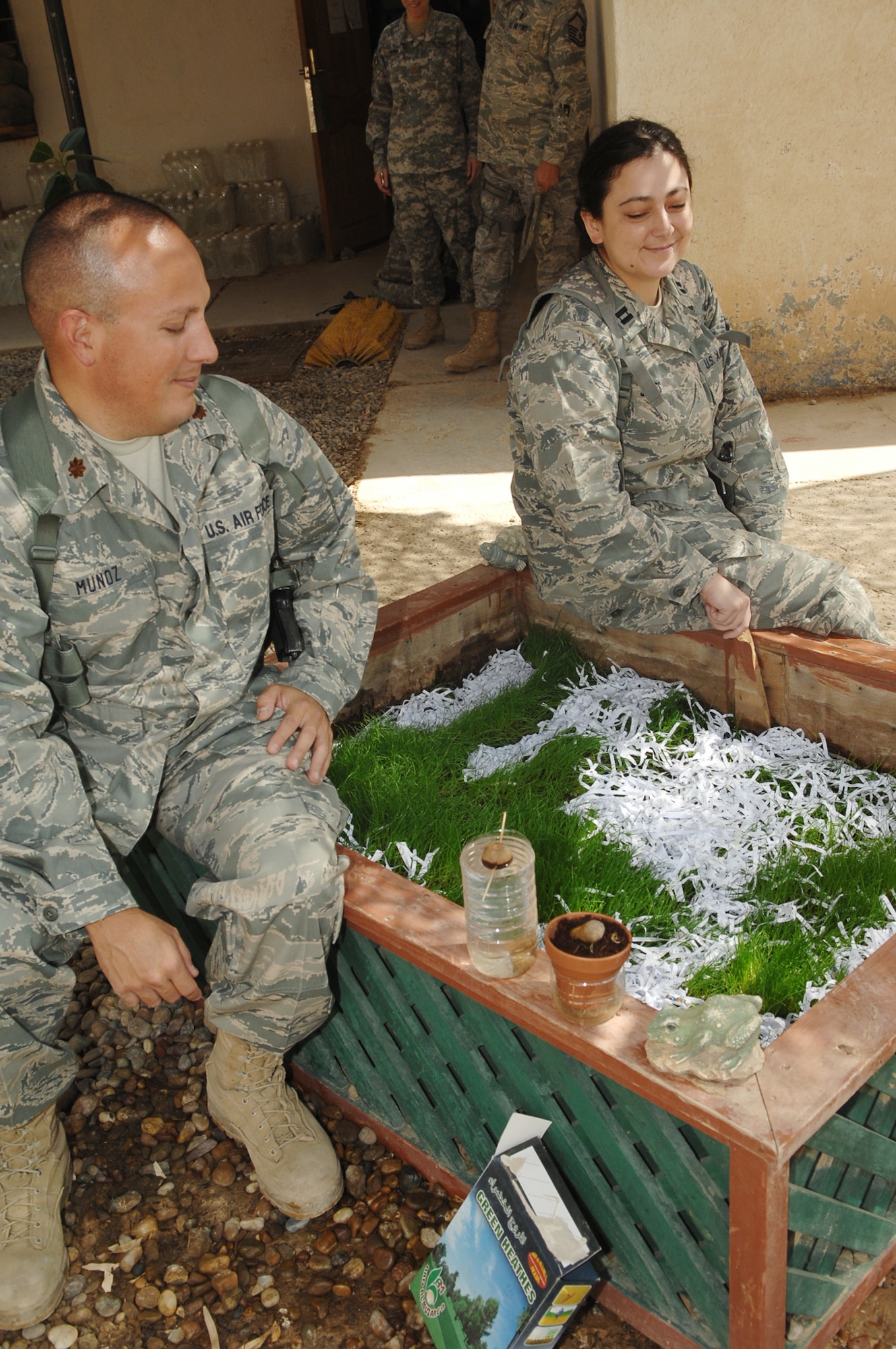 Maj. Derek Munoz and Capt. Joy Jones sit by a patch of grass cultivated by mental health technicians outside the combat stress clinic Oct. 7, 2009, at Camp Taji, Iraq. Major Munoz and Captain Jones are 332nd Air Expeditionary Wing psychologists. The Airmen are two of the four 332nd AEW mental health professionals embedded with the Army's 55th Medical Company here. (U.S. Air Force photo/Senior Airman Andria J. Allmond) 