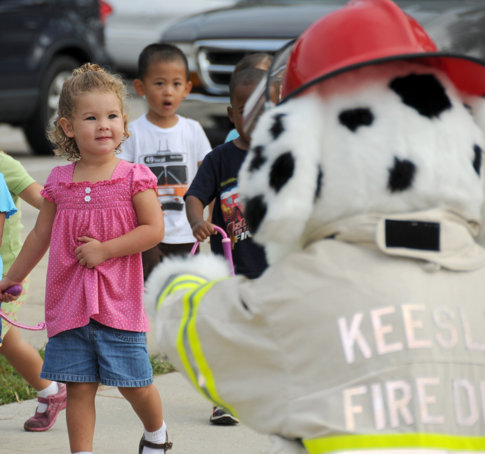 Two-year-olds Keira Brindle, left, and Julian Ozaeta meet Sparky the Fire Dog during a visit to the child development center Oct. 6 for Fire Prevention Week.  Keira is the daughter of Staff Sgt. Damon and Cynthia Brindle, 335th Training Squadron.  Julian’s parents are Capts. Jennifer Reodica and Lee Ozaeta, 81st Surgical Operations Squadron. The fire department conducted a fire drill and gave out fire hats and coloring books. (U.S. Air Force photo by Kemberly Groue)