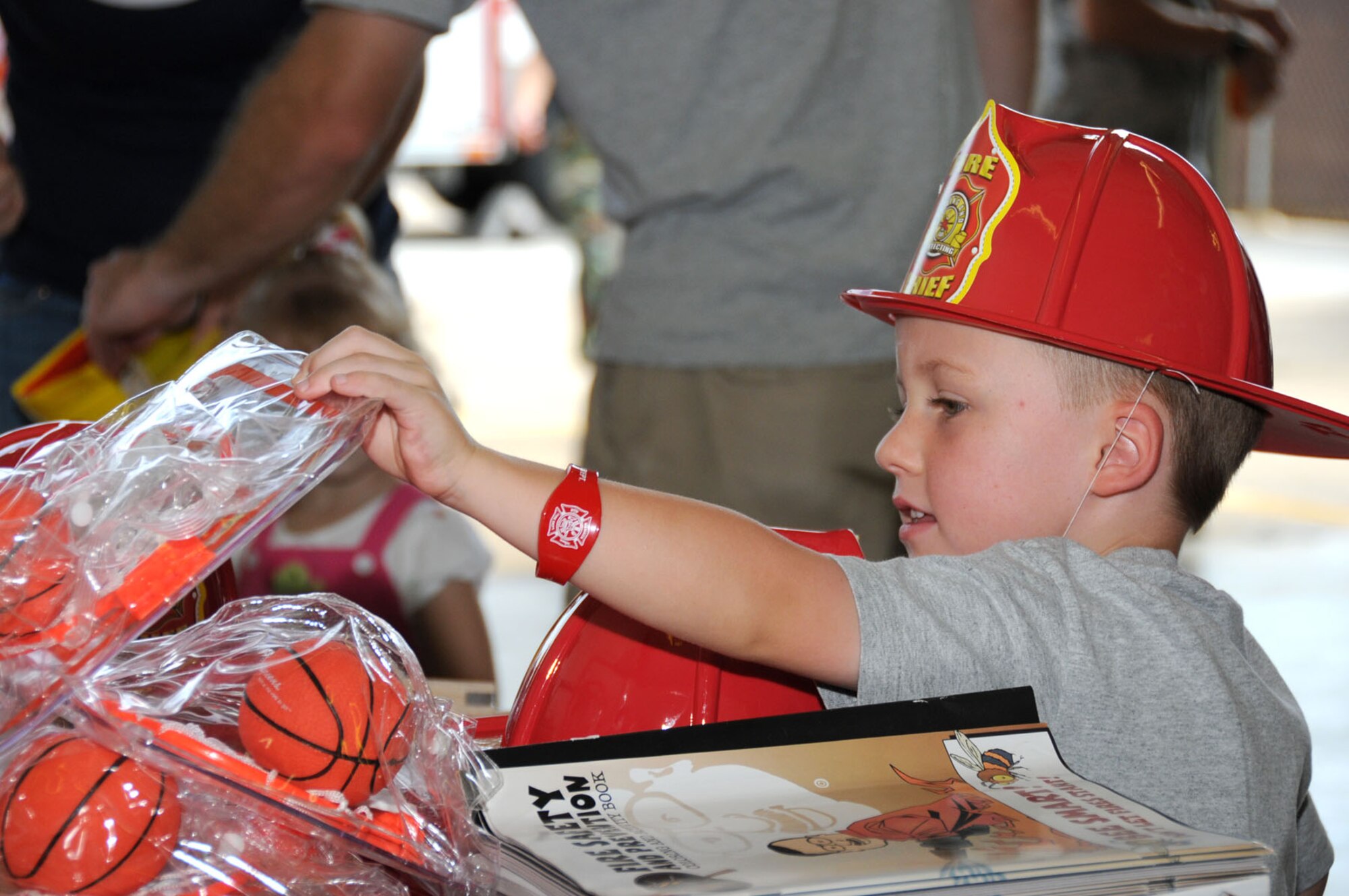 Zachary Edwards, 4, browses through the giveaways at the fire department’s open house Saturday.  His parents are Master Sgt. Craig and Kristy Edwards, 81st TRSS.  (U.S. Air Force photo by Kemberly Groue)