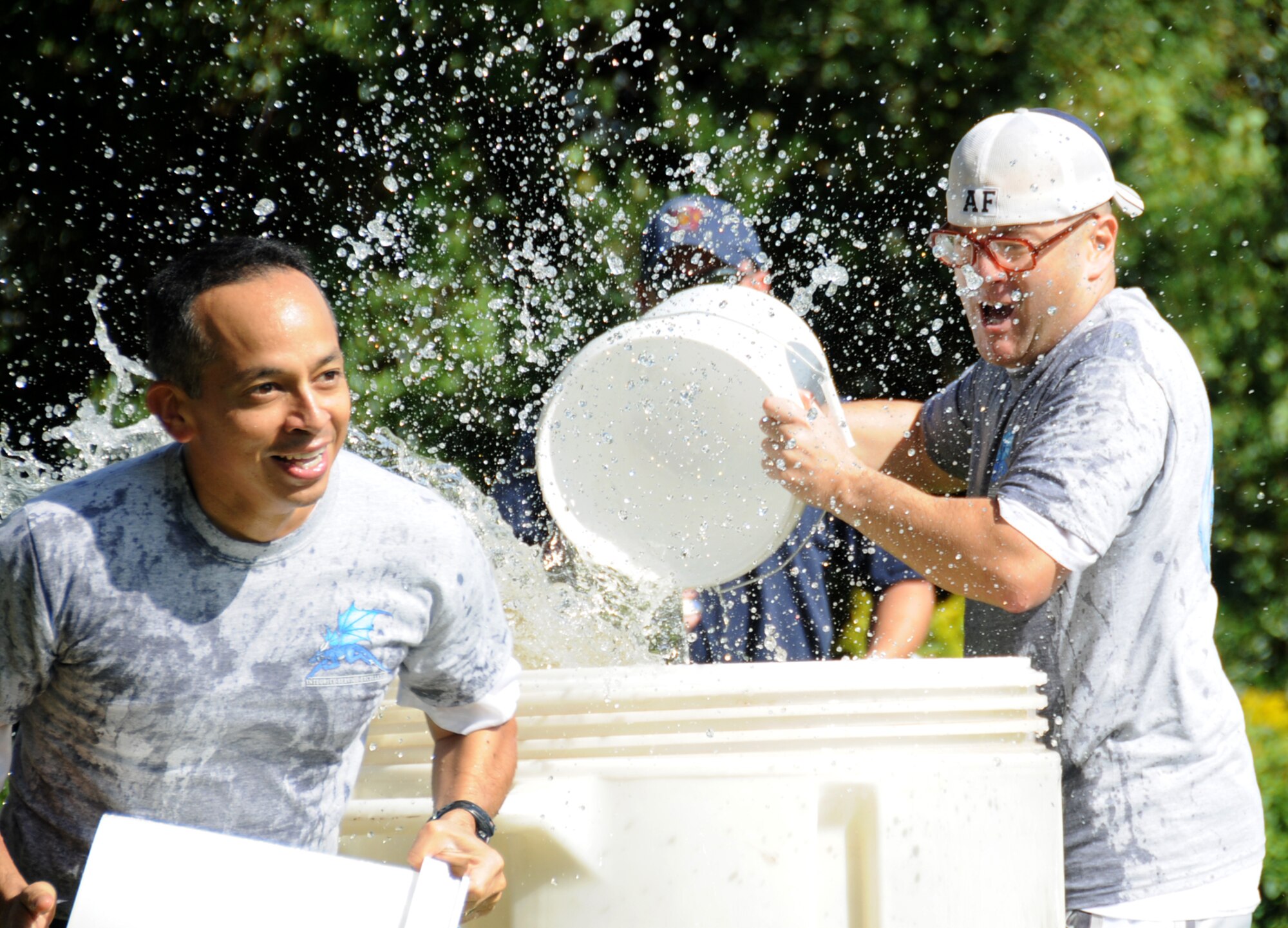 Maj. Robert Paleo, 81st Training Wing, and Lt. Col. Randolph Toris, 81st Comptroller Squadron commander, members of the Mighty Dragons team, send the water flying during the bucket brigade during the fire muster Friday at marina park.  The winning team from the 81st Training Group, Dragon Lynn’s, was comprised of Col. Lynn Connett, commander; Lt. Col. Skip Adams, deputy commander; Chief Master Sgt. Billy Abbott, chief enlisted manager; Lt. Col. Janet Haug, 81st TRSS commander, and Lt. Col. William Hamant, 332nd TRS commander.  (U.S. Air Force photo by Kemberly Groue)