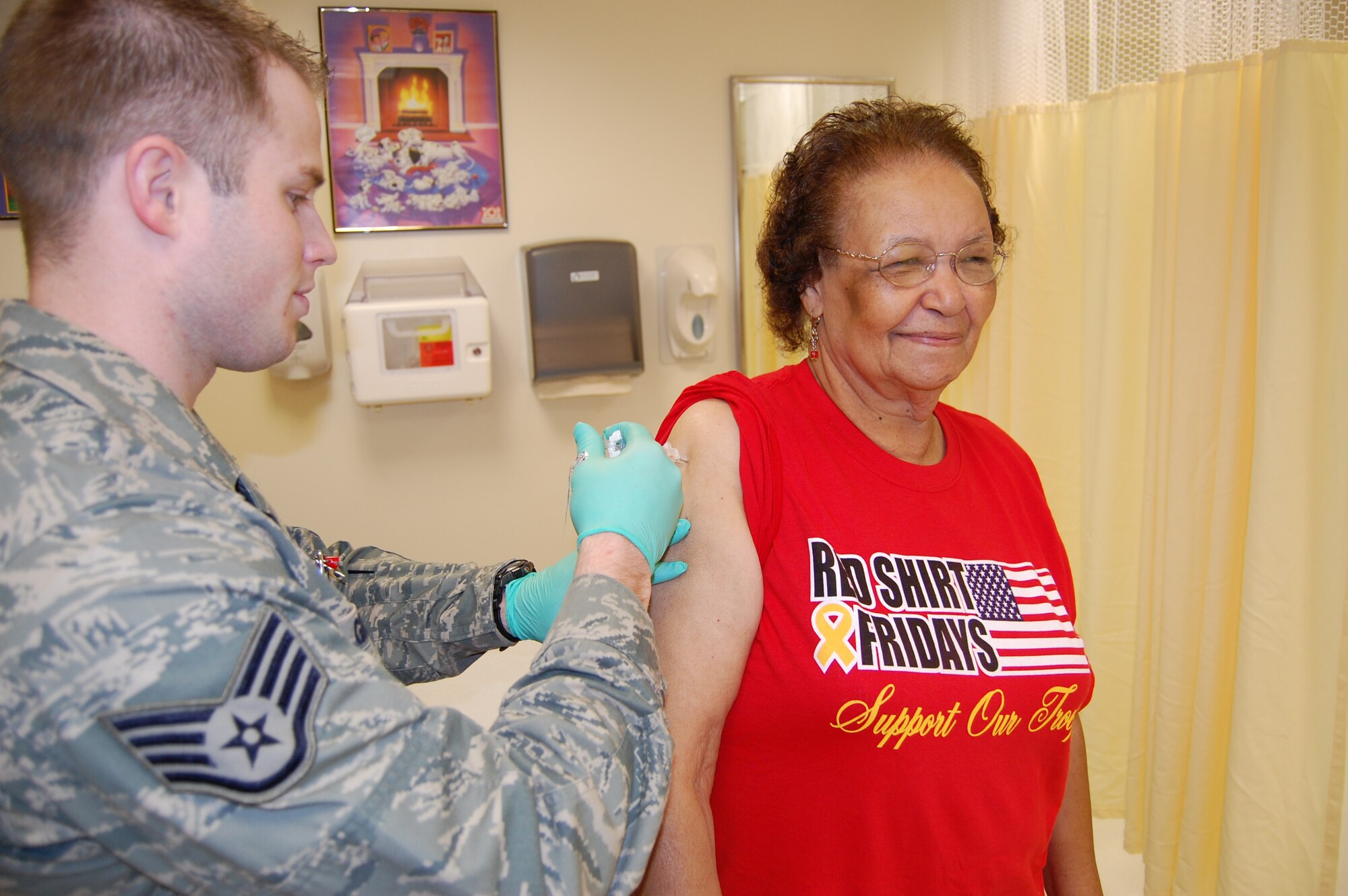 Staff Sgt. Brian Greer, 81st Inpatient Operations Squadron, administers a flu shot to Adell Lancaster Oct. 9 in the Keesler Medical Center Immunization Clinic.  She and her husband, retired Senior Master Sgt. Tom Lancaster, reside in Gulfport.  (U.S. Air Force photo by Steve Pivnick)