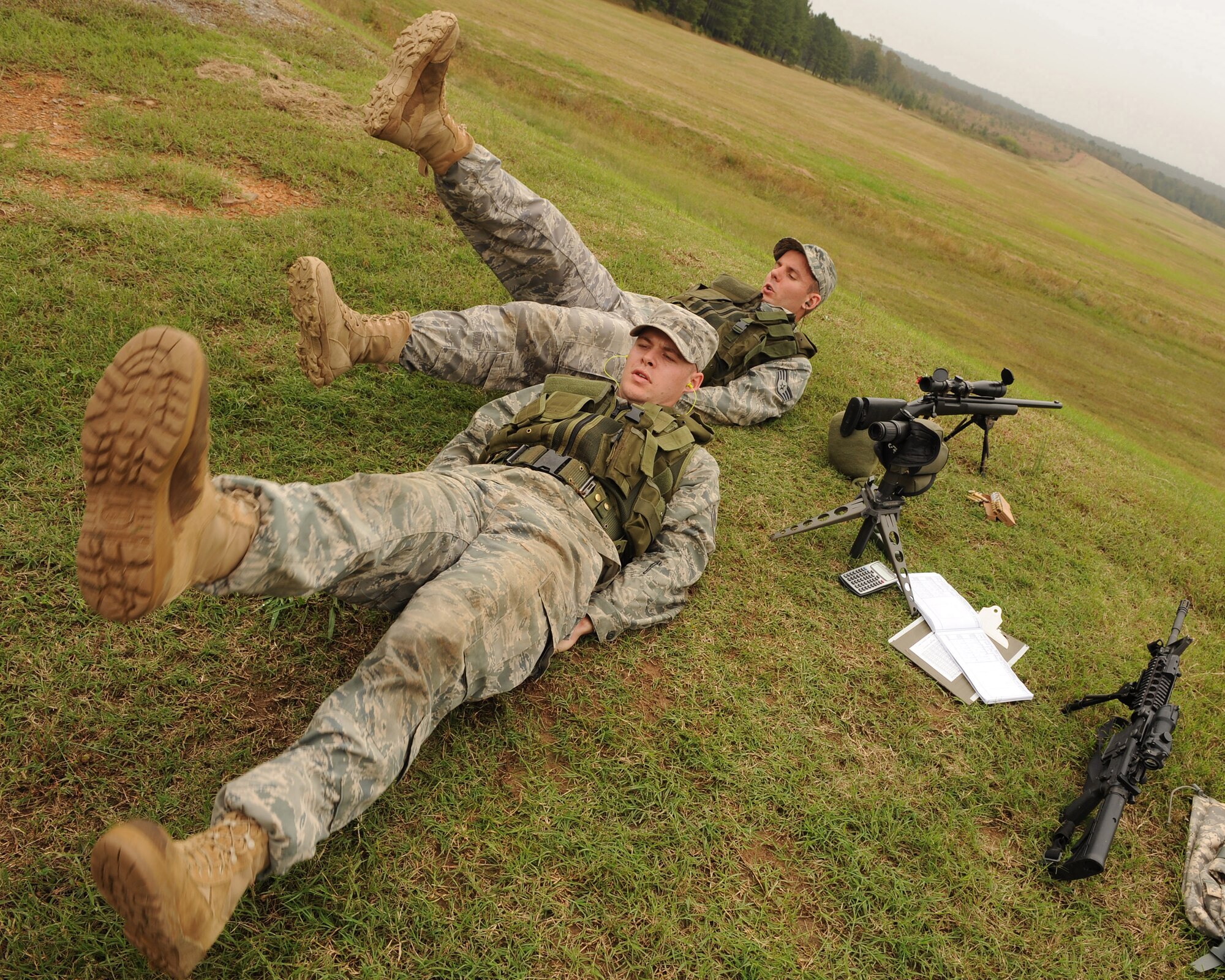 Staff Sgt. Carl Hook and Senior Airman Dane Coppini, 19th Security Forces sharp shooters, perform flutter kicks Oct. 8 to accelerate their heart rates prior to shooting a series of targets down range at Camp Robinson.  Sergeant Hook and Airman Coppini use push-ups, flutter kicks and running to help condition their breathing and heart rate. This helps to simulate the way real world situations could affect shooting mechanics. (U.S. Air Force photo by Staff Sgt. Chad Chisholm)