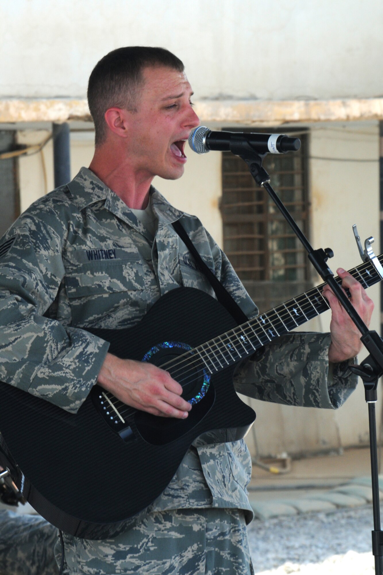 KIRKUK REGIONAL AIR BASE, Iraq - Staff Sgt. Clint Whitney, AFCENT Band Falcon, guitarist and vocalist, performs at the 506th Expeditionary Civil Engineer Squadron compound here Oct. 8.  Falcon performed for Airmen, Soldiers and civilian contractors at various locations on base including the dining facility, the Wagon Wheel stage and the Clamtina community center from Oct. 7-9. Sergeant Whitney is deployed in Southwest Asia from the U.S. Air Force Heartland of American Band, Offutt Air Force Base, Neb.  (U.S. Air Force photo/Master Sgt. James Law)