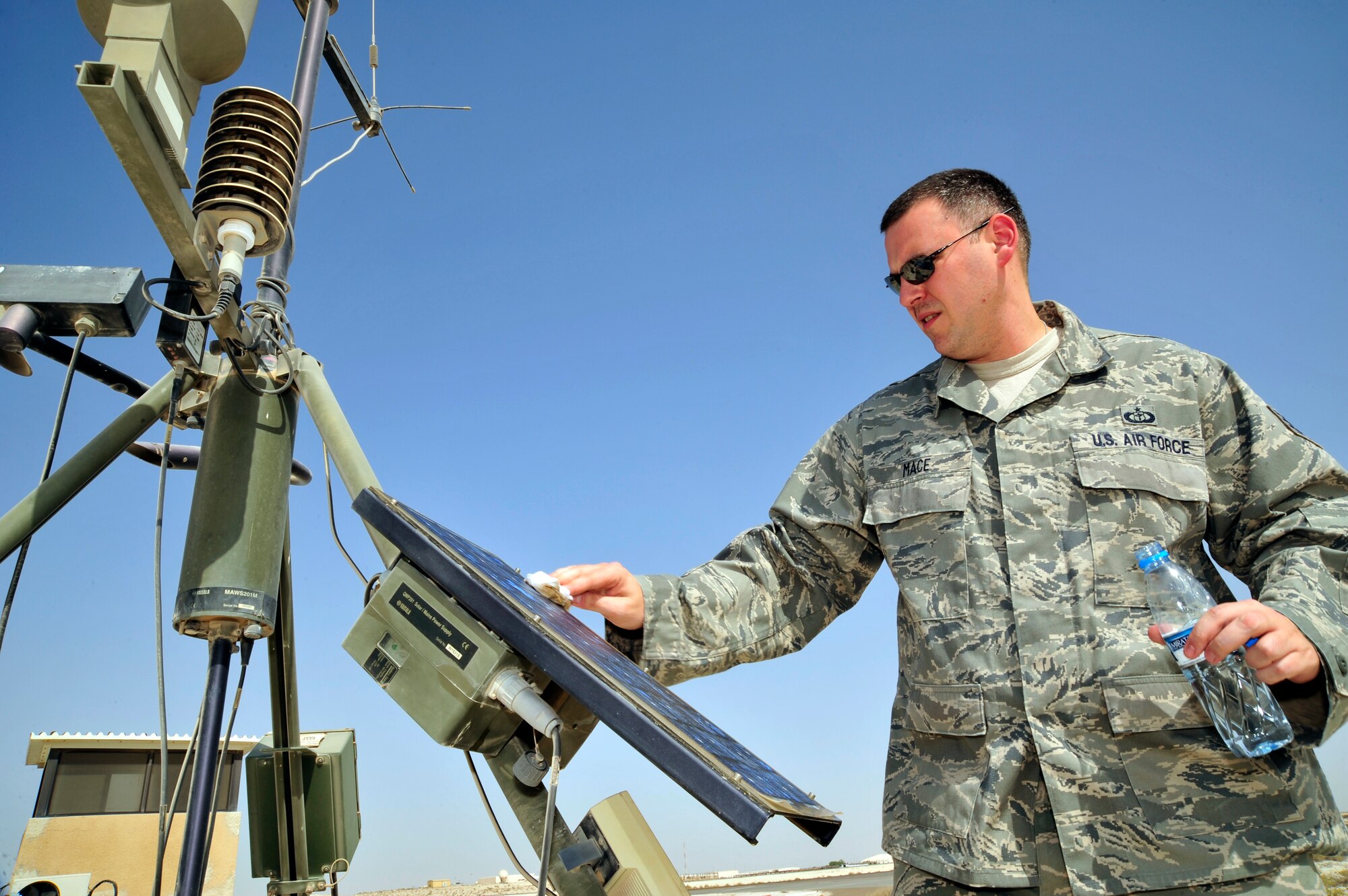 SOUTHWEST ASIA -Staff Sgt. Joshua Mace, 380th Expeditionary Operations Support Squadron weather forecaster, cleans the surface of a solar power cell on a tactical meteorological observation system here Oct. 13, 2009. Sergeant Mace is deployed from Beale Air Force Base, Calif., and hails from Eugene, Ore. (U.S. Air Force photo/Tech. Sgt. Charles Larkin Sr)