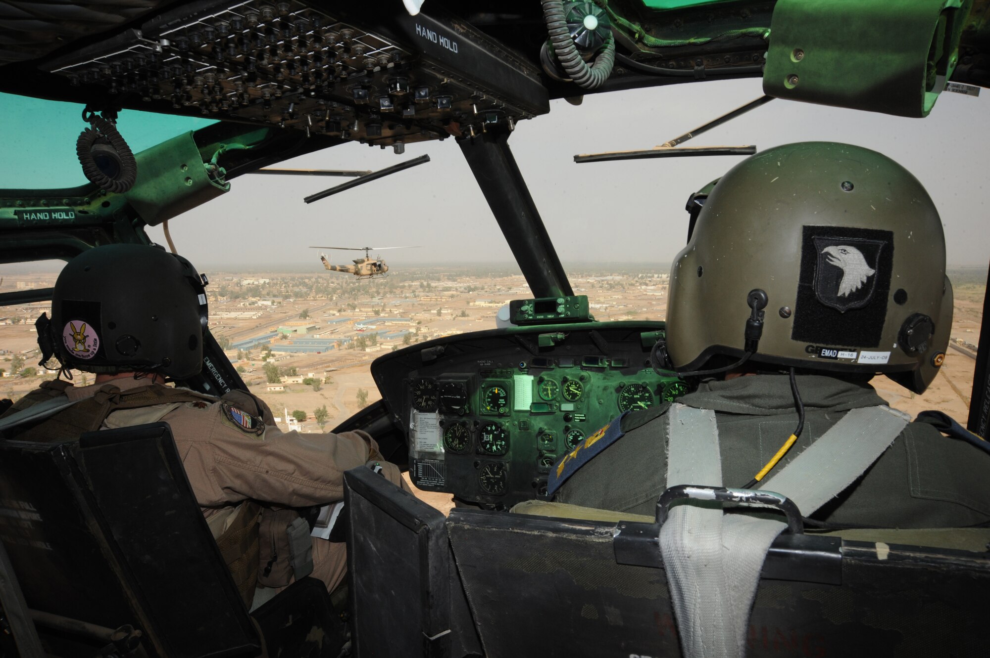 CAMP TAJI, Iraq -- Air Force Maj. Jack Swinehart (left), 721st Air Expeditionary Advisory Squadron UH-1H pilot, oversees an Iraqi pilot performing aerial formation flying procedures here Oct. 8, 2009. The major trains Iraqi students on approaches, take-offs, landings and remote operations consisting of landing in unfamiliar landing zones. U.S. Air Force instructor pilots assigned to the 721st AEAS train, advise and assist Iraqi helicopter pilots around the clock, helping the Iraqis develop their own air force. Major Swinehart is deployed from and a native of Fort Rucker, Ala.  (U.S. Air Force photo/Tech. Sgt. Johnny L. Saldivar)