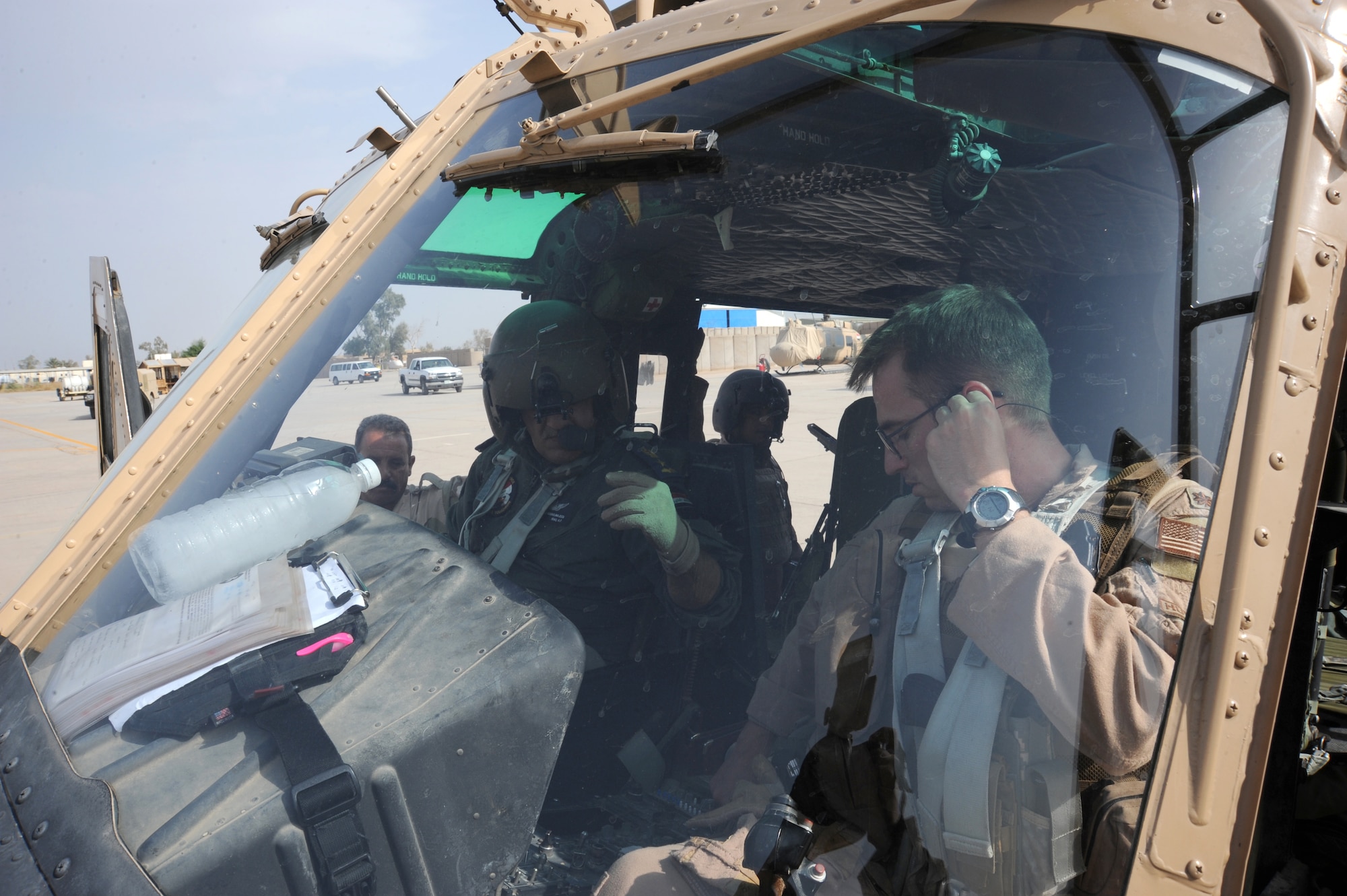 CAMP TAJI, Iraq -- Air Force Maj. Jack Swinehart (right), 721st Air Expeditionary Advisory Squadron UH-1H pilot, observes an Iraqi pilot performing preflight procedures here prior to a helicopter training mission Oct. 8, 2009. The major sits side-by-side with Iraqi pilots as they practice approaches, take-offs, landings and aerial maneuver formation flying procedures. U.S. Air Force instructor pilots assigned to the 721st AEAS train, advise and assist Iraqi helicopter pilots around the clock, helping the Iraqis develop their own air force. Major Swinehart is deployed from and is a native of Fort Rucker, Ala. (U.S. Air Force photo/Tech. Sgt. Johnny L. Saldivar)