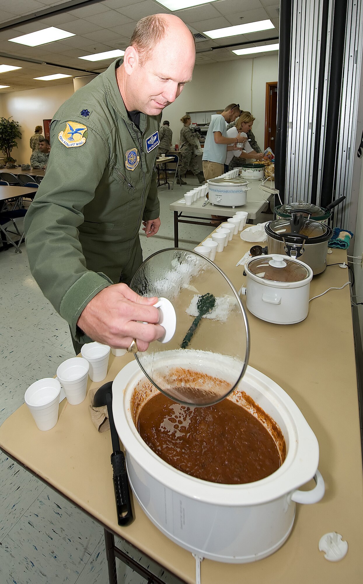 Lt. Col. Jon Fullerton, 436th Airlift Wing director of staff, takes a look at one of 13 chili pots during the wing staff?s first Chili Cook-off at Chapel 2 Oct. 9. Three judges determined the winner of the best chili by color, aroma, taste, after-taste and consistency. (U.S. Air Force photo/ Jason Minto)