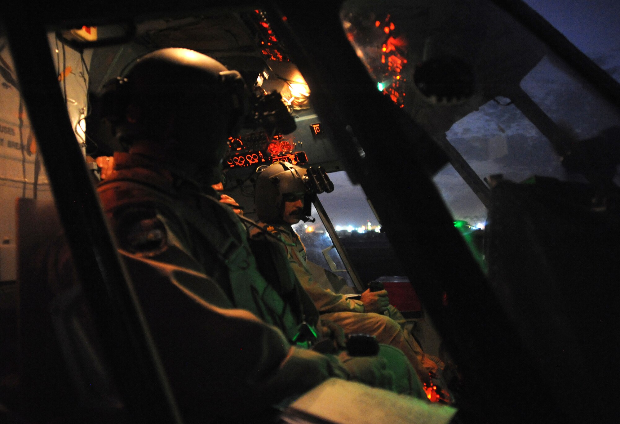 CAMP TAJI, Iraq -- Air Force Major Christopher Elam (left), 721st Air Expeditionary Advisory Squadron Mi-17 pilot, observes an Iraqi air force pilot performing preflight procedures here prior to a helicopter mission using night vision goggles Oct. 7, 2009. The major teaches them how to operate, preflight and maintain NVGs. U.S. Air Force instructor pilots assigned to the 721st AEAS train, advise and assist Iraqi helicopter pilots around the clock, helping them develop their own air force. Major Elam is deployed from Kirtland Air Force Base, N.M., and hails from Evanston, Ill.  (U.S. Air Force photo/Tech. Sgt. Johnny L. Saldivar)

