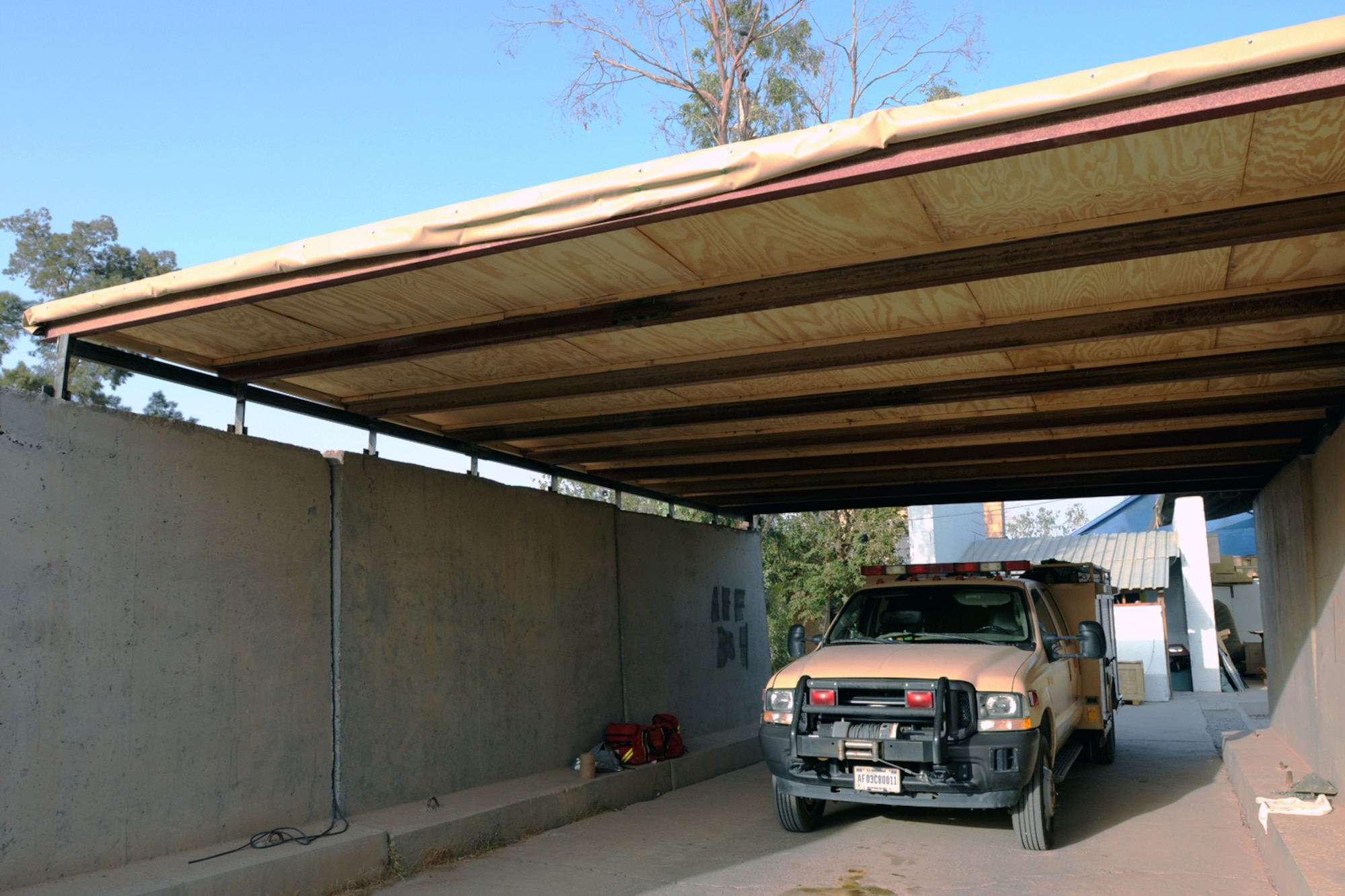 KIRKUK REGIONAL AIR BASE, Iraq - A fire rescue truck and equipment sit under the recently built overhang here Oct 13, 2009.  Airmen assigned to the 506th Expeditionary Civil Engineer Squadron's structures shop recently demonstrated their ingenuity and saved the Air Force money by constructing the protective overhang with scrap materials.  (U.S. Air Force photo/Staff Sgt. Joshua Breckon) 