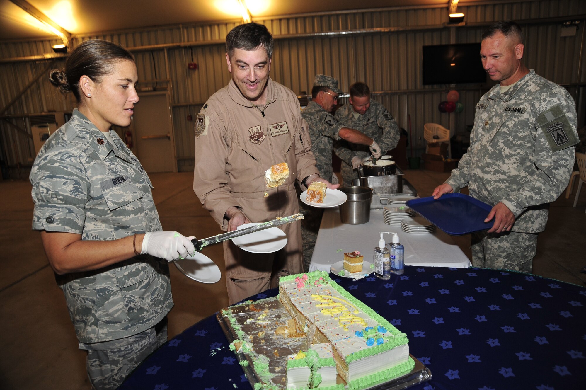SOUTHWEST ASIA—Maj. Kimberly C. Boehm, 380th Expeditionary Force Support Squadron commander flips pieces of cake onto plates, as servers lined-up to scoop ice cream here Oct. 13, 2009 (U.S. Air Force Photo by 2nd Lt. Kidron B. Vestal)
