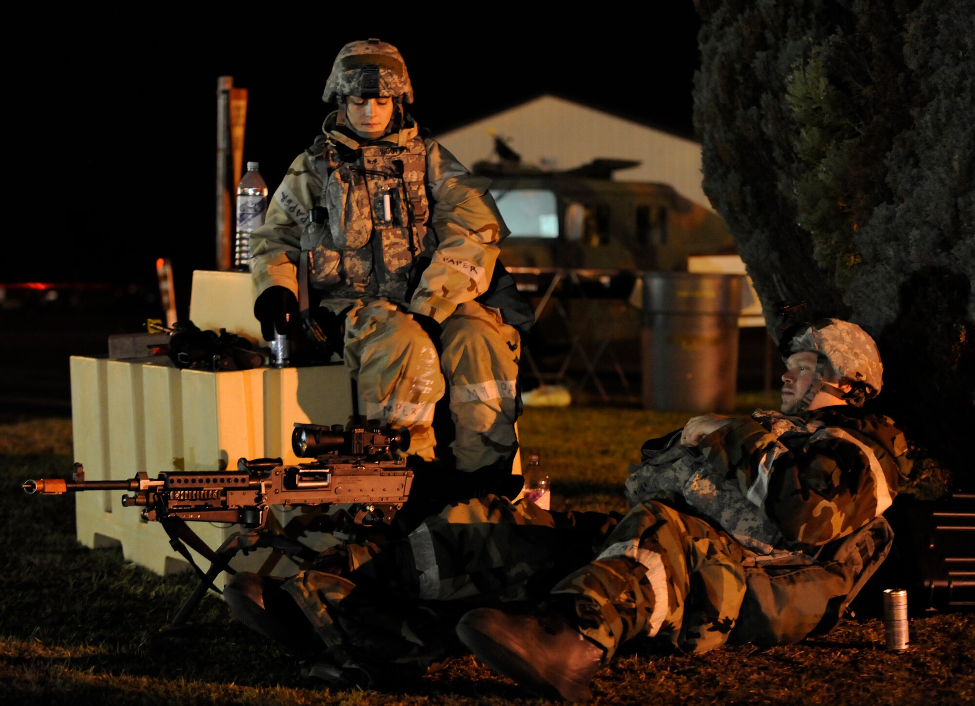 RAF MILDENHALL, England -- Senior Airman Ashley Wootton and Airman Kyle Butters, 100th Security Forces Squadron take a break between exercise scenarios, during the Operational Readiness Inspection Oct. 13.  The two are manning an M-240 B machine gun 100 yards from the entry control point. The ORI tests if Airmen can operate in a deployed environment.  (U.S. Air Force photo/Staff Sgt. Christopher L. ingersoll)