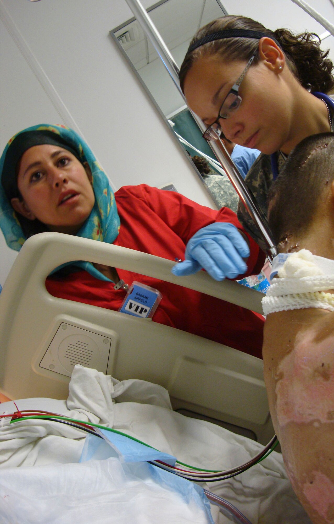 BAGRAM AIRFIELD, Afghanistan -- Laila Farahi (left), a female Afghan National Army soldier, assists 1st. Lt. Nicole Pries (right), Intensive Care Ward nurse, deployed from the David Grant Medical Center, Travis Air Force Base, Calif., with a patient.  She attended a special two-week mentorship program here at the Craig Joint Theater Hospital to work alongside U.S. doctors and nurses to hone her medical skills and get first-hand experience with trauma-based care.  She was one of the first women to ever attend the special program.  (Courtesy photo)            