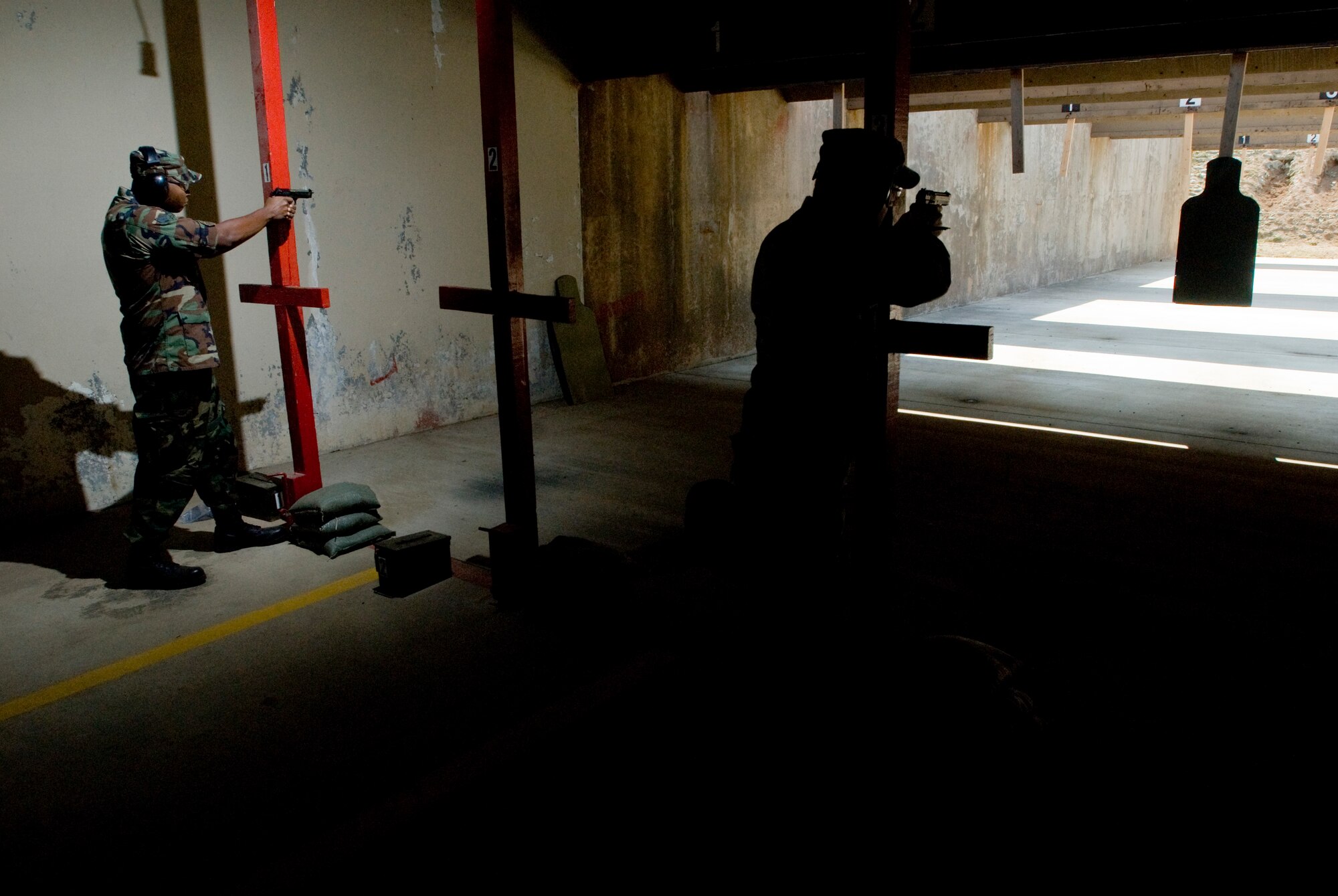 KUNSAN AIR BASE, Republic of Korea -- Senior Airman Curtis Raines and Tech. Sgt James Peck, 8th Logistics Readiness Squadron, fire their M9 pistol at a target during the 8th Secuirty Forces Squadron Combat Challenge Oct.9.The Combat Challenge consisted of a four member team working together to compete various  activities.(U.S. Air Force photo/Senior Airman Jonathan Steffen)