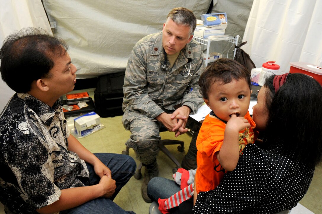 U.S. Air Force Maj. Scott Hughes gathers medical information from a patient with the help of Hasbi, a local interpreter in Padang, Indonesia, Oct. 10, 2009. Hughes, a doctor from the 36th Medical Group on Anderson Air Force Base, Guam, is deployed with an Air Force humanitarian assistance rapid response team to provide medical assistance to those affected by the recent earthquakes.