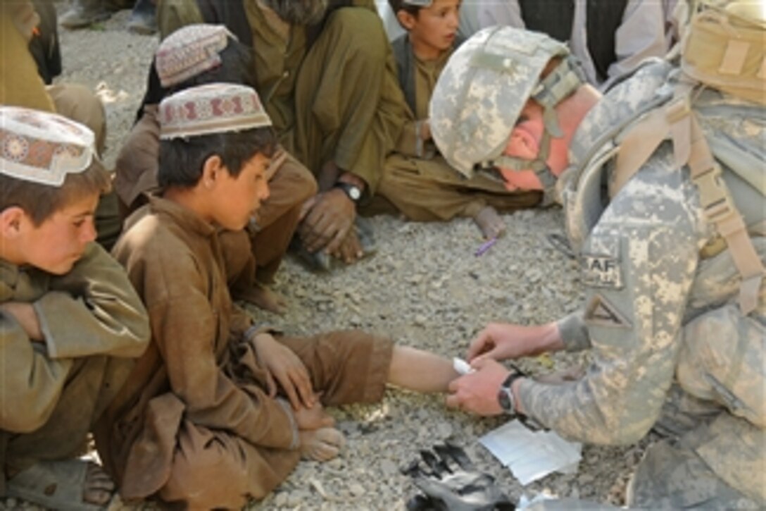 U.S Army Spc. Steven Hamilton (right) gives medical treatment to a 12-year-old Afghan boy in Mowtsi village in Zabul province, Afghanistan, on Oct. 7, 2009.  Hamilton is a medic, attached to Alpha Company, 1st Battalion, 4th Infantry Regiment, United States Army Europe.  U.S. soldiers of 1st Battalion, 4th Infantry Regiment are deployed throughout southern Afghanistan in support of Operation Enduring Freedom.  