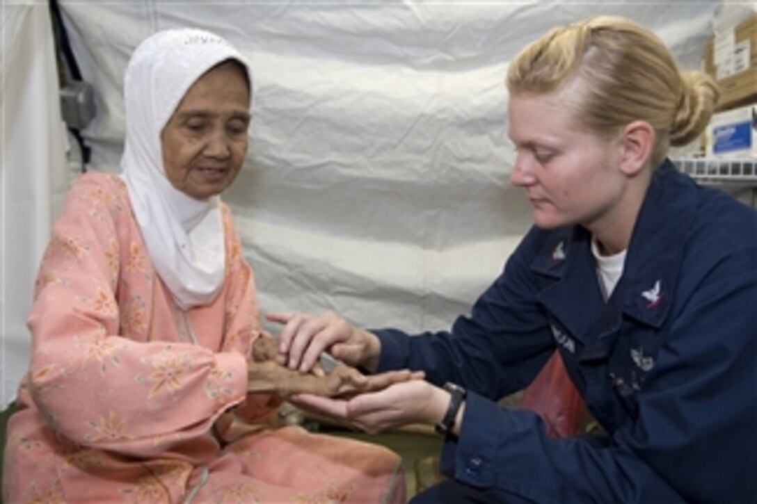 U.S. Navy Petty Officer 3rd Class Brittany Robinson, of the USS McCampbell (DDG 85), examines a patient’s hand at the Humanitarian Assistance Rapid Response Team medical facility in Padang, Indonesia, on Oct. 12, 2009.  Sailors from the McCampbell and the amphibious transport dock ship USS Denver (LPD 9) volunteered their time at the hospital, which is providing medical treatment to residents of West Sumatra after two earthquakes.  Amphibious Force 7th Fleet is directing the U.S. military effort in response to a request by the Indonesian government.  