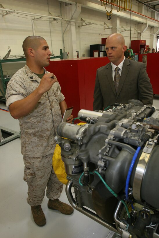 Sgt. Edgar L. Leon, a helicopter engine mechanic with Marine Aviation Logistics Squadron 39, Marine Aircraft Group 39, 3rd Marine Aircraft Wing, I Marine Expeditionary Force, explains the process of dissasembling a T-700 engine to Maj. Travis R. Tibbetts, a  H1 intermediate weapon support team leader with Naval Inventory Control Point, during a "Boots on the Ground" outreach event, here Oct. 14. The Marines in the squadron sections highlighted improvements they've made and demonstrated how they accomplished them.  (Official U.S. Marine Corps photo by Cpl. Christopher O'Quin)(Released)
