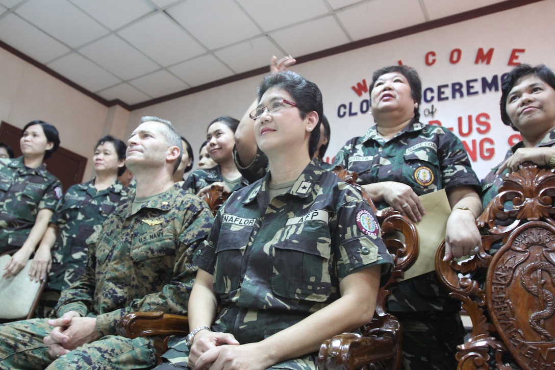 Lt. Cmdr. Daniel J. Hohman, a surgeon with the 1st Marine Aircraft Wing, and Brig. Gen. Nelia B. Buenaflor, the Chief Nurse of Armed Forces of the Philippines, take their seats at the Professional Nursing Symposium in Manila, Philippines, on Oct. 16. The symposium was an opportunity for military medical personnel from both the Philippines and United States to exchange medical procedures and techniques.
