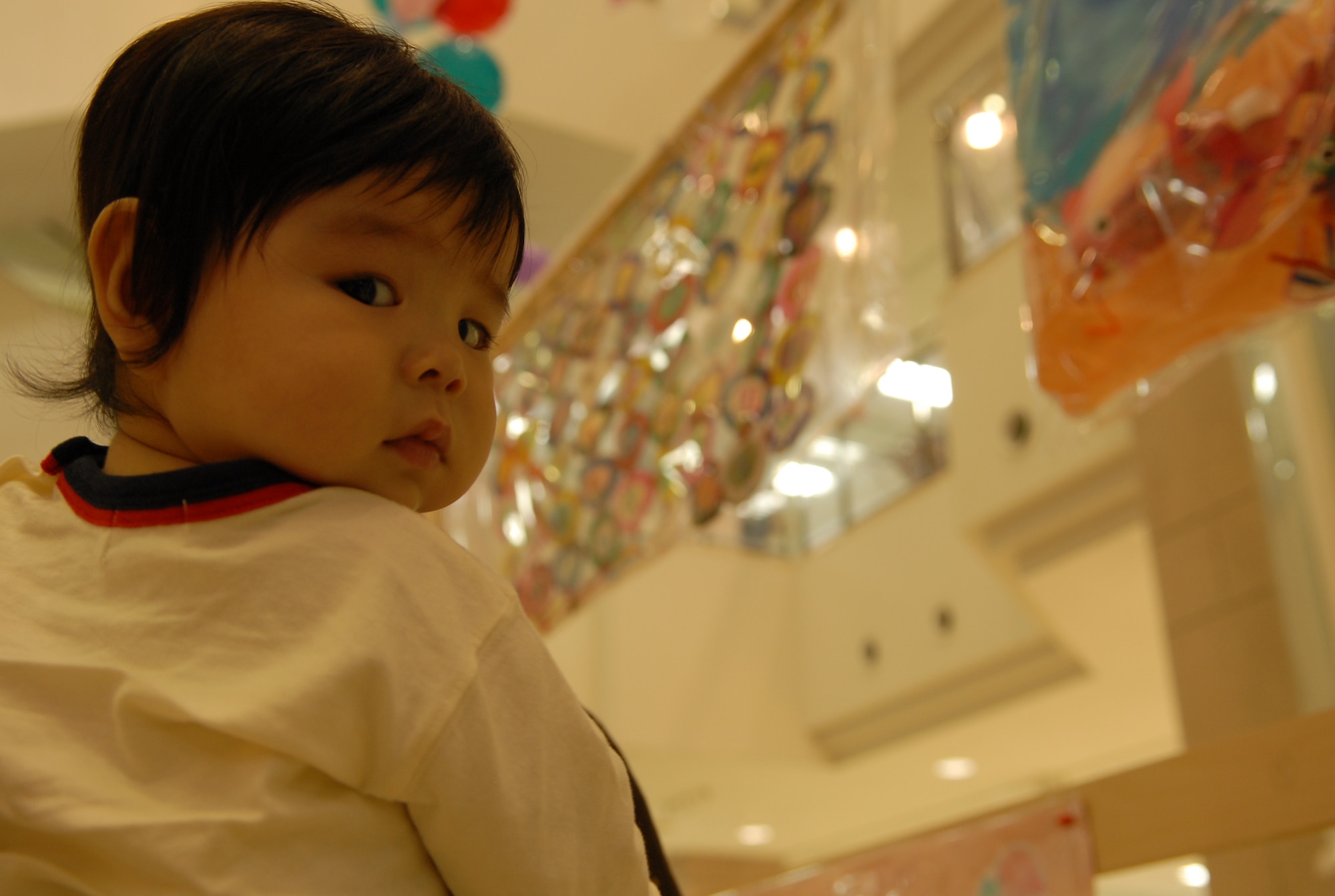 A baby takes a break from viewing the art to mean mug the camera at the Kadena Special Olympics Art Exhibit Oct. 15. More than 300 works of art created by special needs students from elementary and junior high schools in Okinawa City, Nago City, Kadena Town, and Chatan were on display. (U.S. Air Force Photo/1st Lt. Joe Kreidel)