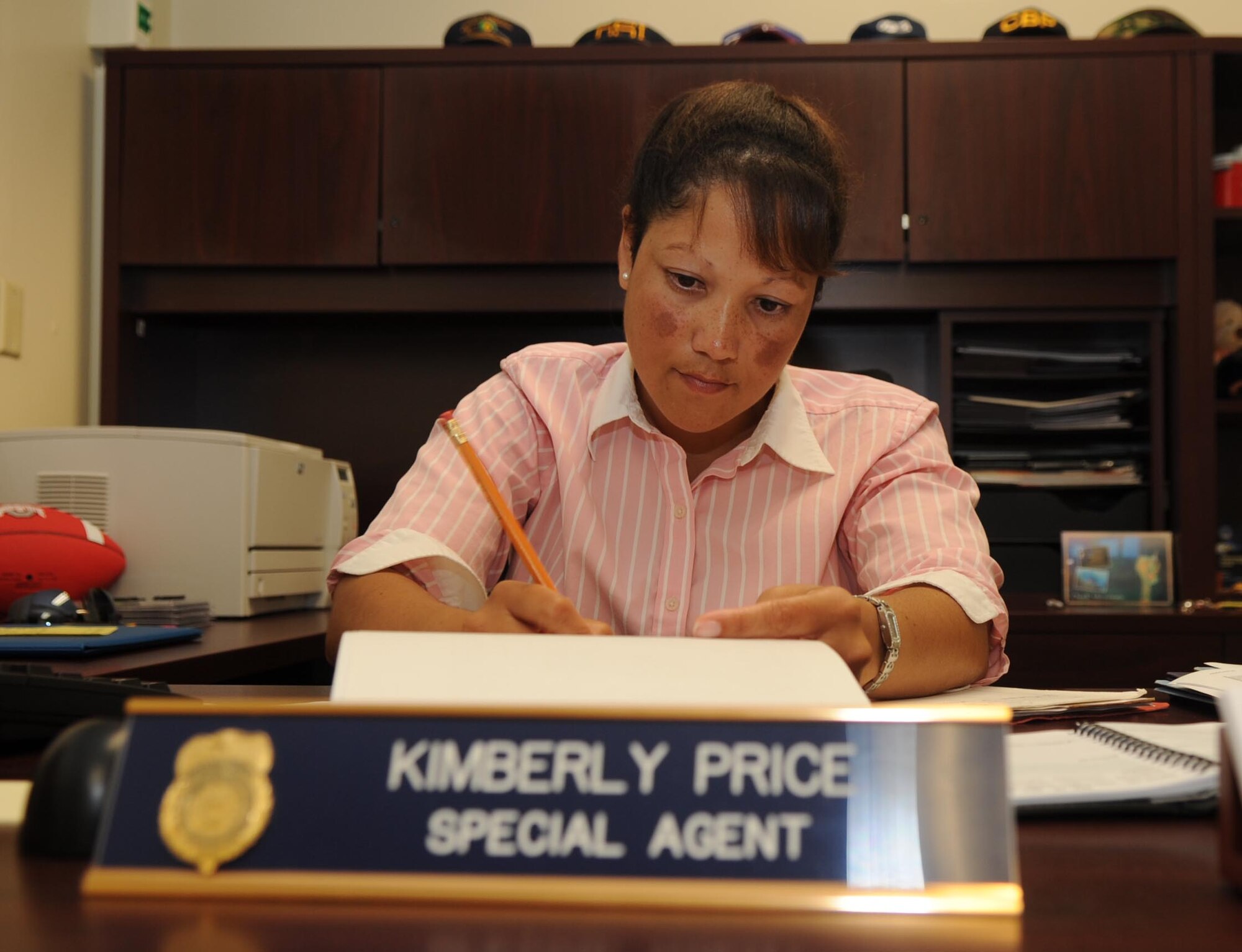 Special Agent Kimberly Price, Air Force Office of Special Investigations Detachment 602 superintendent, reviews training records for her subordinate agents on Andersen Air Force Base, Guam, Oct. 01. Agent Price was selected as "Top Performer" by Special Agent Drew Sanguinetti, AFOSI Det. 2 Commander.  (U.S. Air Force photo by Senior Airman Christopher Bush)

