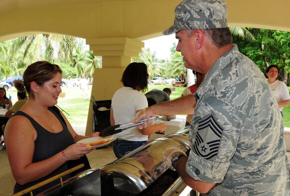 ANDERSEN AIR FORCE BASE, Guam - Chief Master Sgt. Tim Byrd, 36th Maintenance Group superintendent, serves a hamburger to Airman 1st Class Kristin Starkey, 36th Force Support Squadron, Oct. 9 at Tarague Beach pavilion here during Junior Enlisted Appreciation Day. Team Andersen chiefs served Airmen as their way of giving back to the junior enlisted personnel. (U.S. Air Force photo by Airman 1st Class Julian North)
