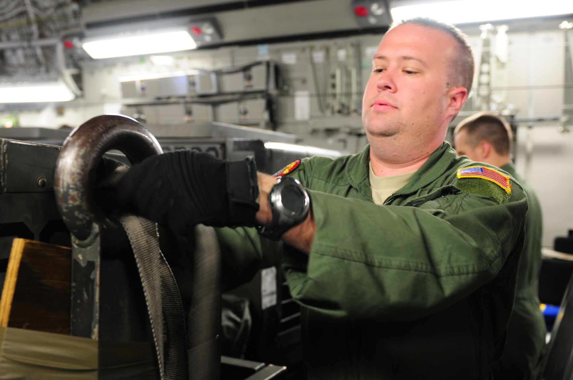 Staff Sergeant Lucas Compton, loadmaster for the 535th Airlift Squadron, 15th Airlift Wing at Hickam Air Force Base, Hawaii, begins to unbuckle the straps to a piece of cargo on board the C-17 Globemaster III that arrived to Agra Air Force Base, India, Oct. 15. 