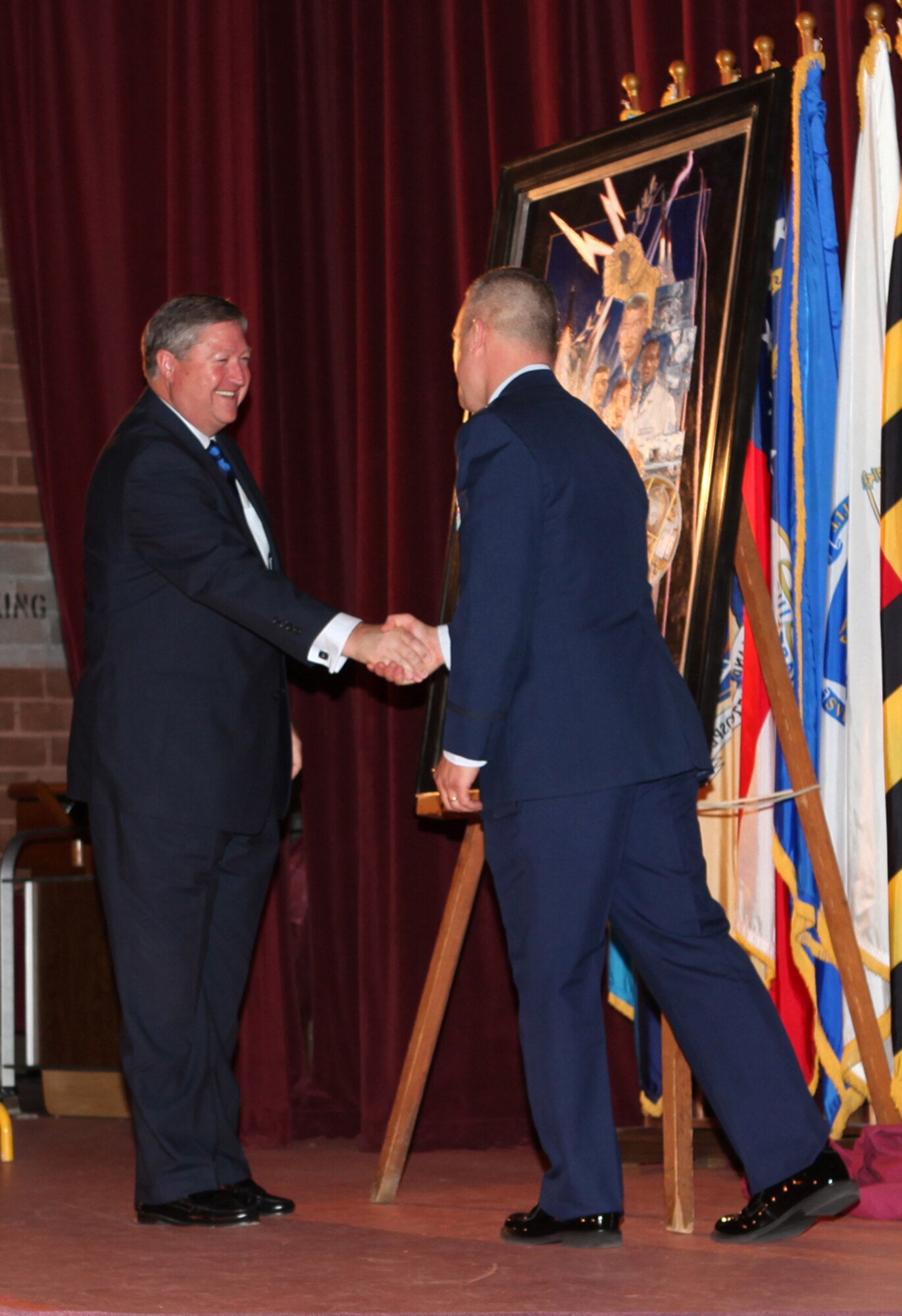 Secretary of the Air Force Michael Donley shakes hands with Capt. Warren Neary, Twentieth Air Force, at the F.E. Warren Theater Oct. 9. The 50th Anniversary commemorative painting by Captain Neary will be displayed in Secretary Donley’s office as part of the Air Force art program. (U.S. Air Force Photo by Berni Ernst)
