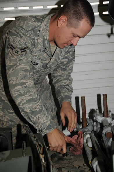 ELLSWORTH AIR FORCE BASE, S.D. -- Airman 1st Class Christopher Bratton, 28th Civil Engineer Squadron electrical power production apprentice, unscrews bolts to a roller sheave in order to remove them from a mobile aircraft arresting system, Oct. 15.  Airman Bratton maintains and cleans the MAAS by removing all parts and pieces during a maintenance checkup, which occurs every three years. (U.S Air Force photo/Airman 1st Class Anthony Sanchelli)
