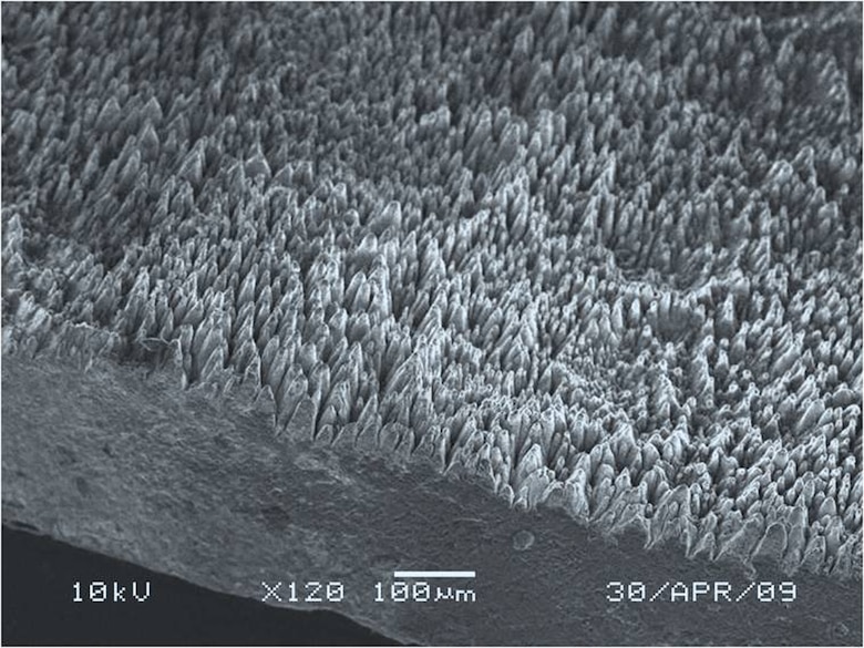 The surface structure of black silicon, as imaged by an electron microscope, contains towers and valleys that dramatically increase the substance's surface area. Physicists theorize the structure contributes to black silicon's efficiency in absorbing light. (U.S. Air Force photo)