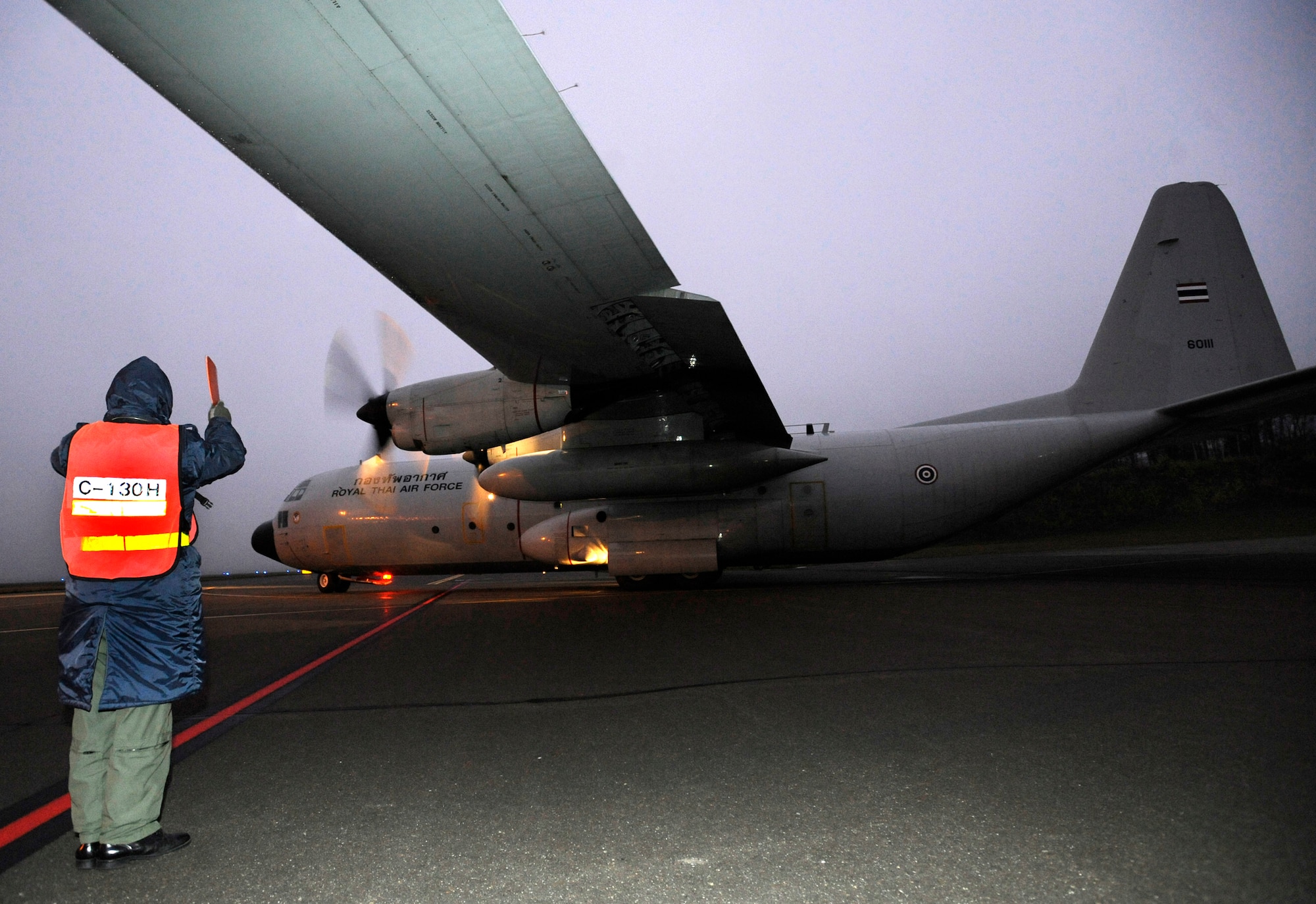 ELMENDORF AIR FORCE BASE, Alaska -- An Airman from the Royal Thai air force marshals a C-130 Hercules out to the runway, Oct.  14.  during Red Flag-Alaska 10-01. This is the fourth RF- Alaska exercise the Royal Thai Air Force has participated in. The first year of participation was in 2003. By participating in RF-Alaska, Thailand continues a close diplomatic relationship with the U.S. which goes back 176 years making Thailand one of the longest allies the U.S. has had. (U.S. Air Force photo/Senior Airman Matt Coleman-Foster)