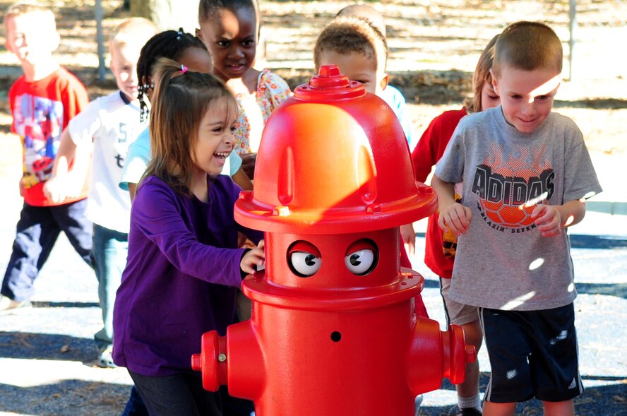 Children from the child evelopment center play follow the leader with Pluggie, the fire hydrant, during Fire Prevention Week at Seymour Johnson Air Force Base, N.C., Oct. 8. Throughout the week, the 4th Civil Engineer Squadron fire department performed demonstrations at various locations around base to spread the word about preventing fires. (U.S. Air Force photo/Airman 1st Class Rae Perry)