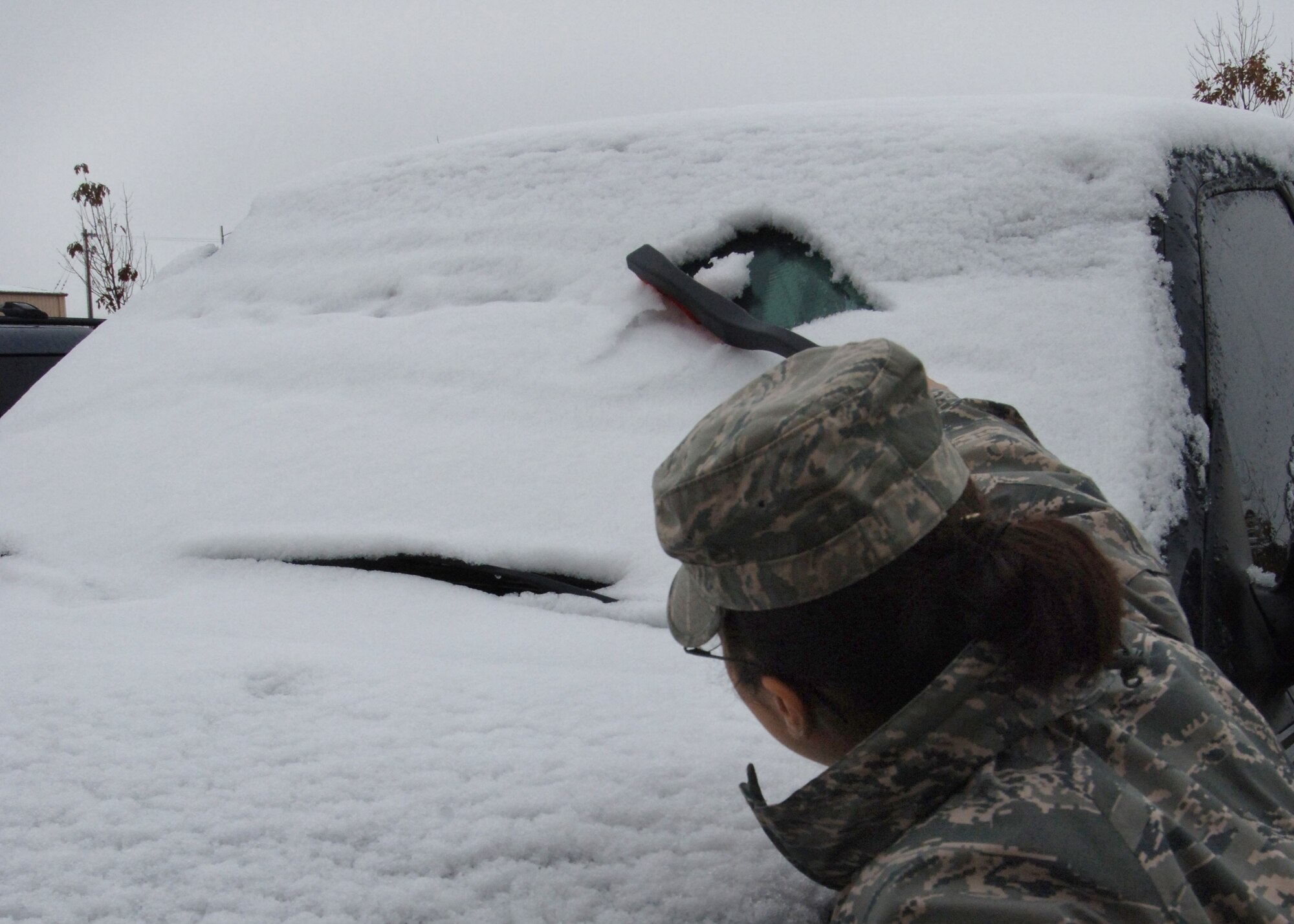 An Airman removes snow from her windshield Oct. 15 on Grand Forks Air Force Base, N.D. (U.S. Air Force photo by Senior Airman R. Michael Longoria)