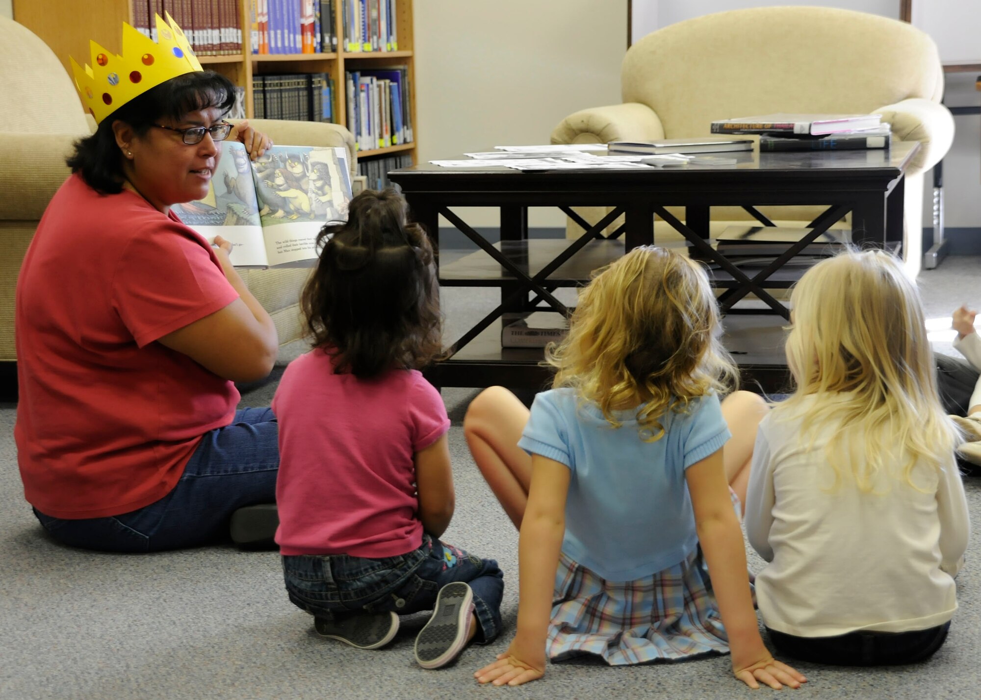 CANNON AIR FORCE BASE, N.M. -- Loretta Croke, 27th Special Operations Force Support Squadron, reads "Where the Wild Things Are" to children at the base library  Oct 14. The library and the Child Development Center conducts seven story times a month that geared primarily for children who are five and younger. For more information on times and dates, call the library at 784-2786. (U.S. Air Force photo/ Senior Airman Erik Cardenas)