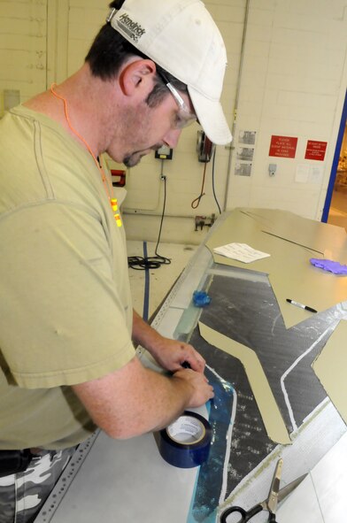 Merrell Ussery makes a template for a C-5 wing tip repair. U. S. Air Force photo by Sue Sapp