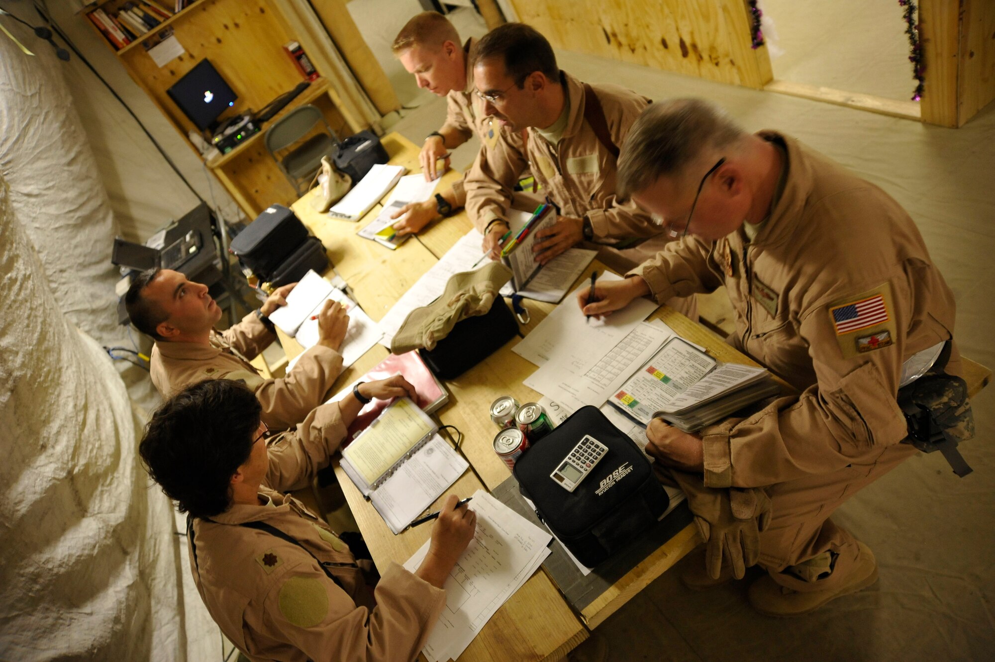 Airmen from the 451st Aeromedical Evacuation Squadron at Kandahar Air Field complete paperwork prior to a mission brief Oct. 6, 2009. The unit's mission that night took them across Afghanistan to connect U.S., coalition and local patients with necessary medical care. (U.S. Air Force photo/Staff Sgt. Angelita Lawrence)