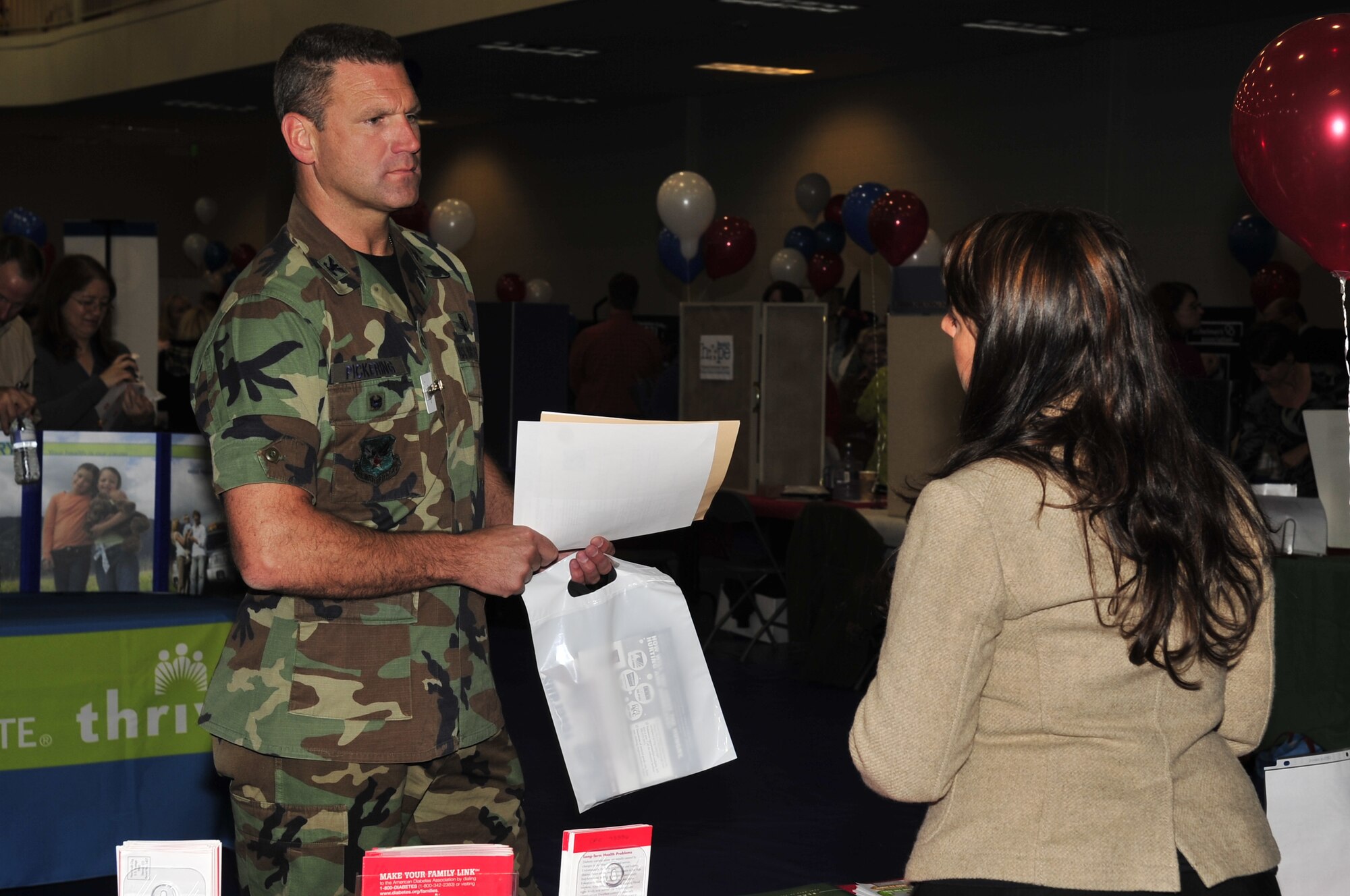 Buckley Air Force Base, Colo.-- After giving an opening speech, Col. Trent Pickering, 460th Space Wing vice commander, collects information from different charities at the Combined Federal Campaign kick off, Oct. 14, 2009. The CFC is a way for federal employees to come together and contribute to local and global charities. (U.S. Air Force photo by Airman 1st Class Manisha Vasquez)