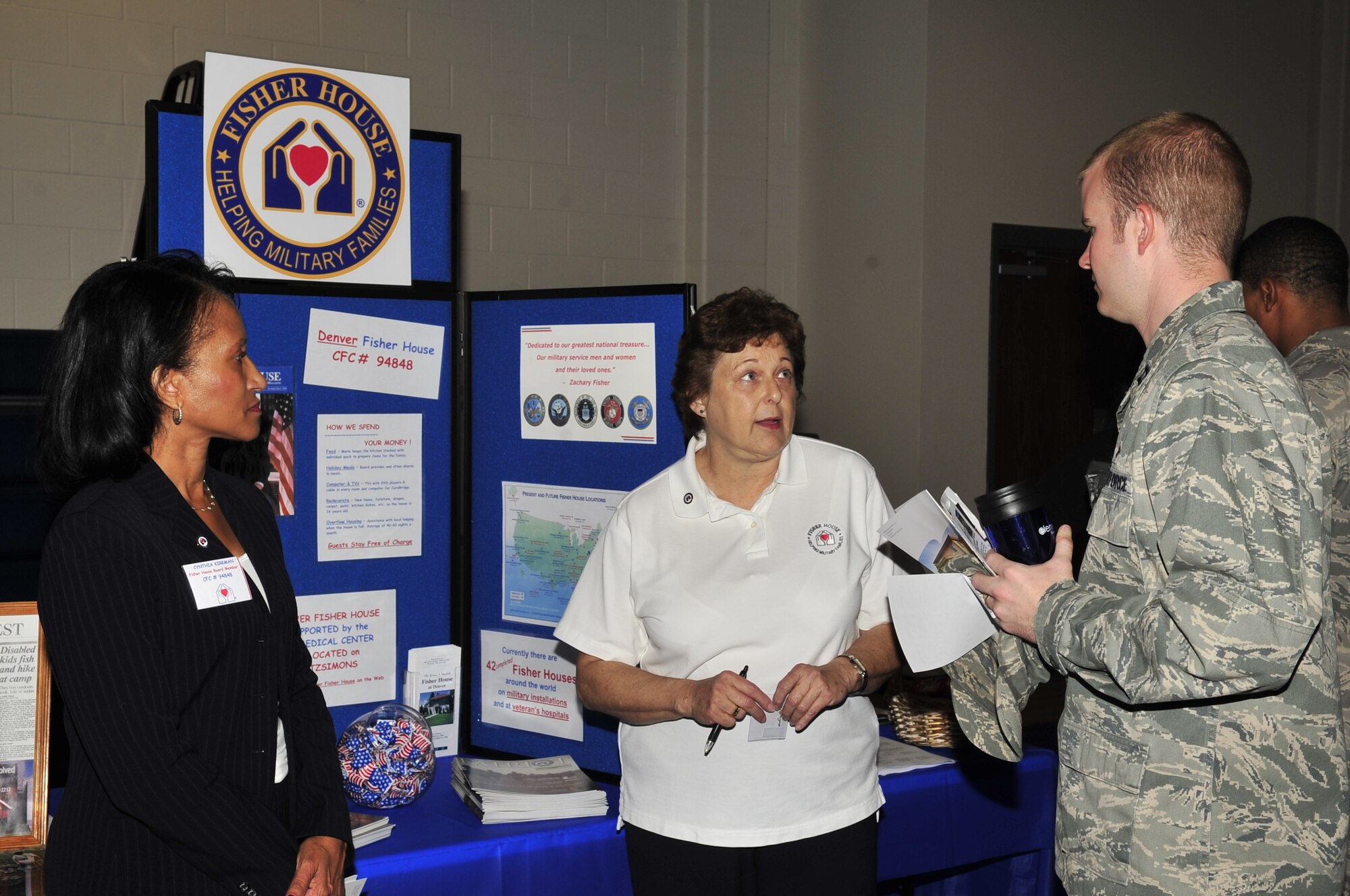 Buckley Air Force Base, Colo.-- Fisher House association board members Cynthia Kirkman and Carol Meyer provide information about their organization to Capt. Dave Walker, 460th Space Wing legal office, at the kick off of the Combined Federal Campaign, Oct.14, 2009. Fisher House strives to help military families in need. (U.S. Air Force photo by Airman 1st Class Manisha Vasquez)