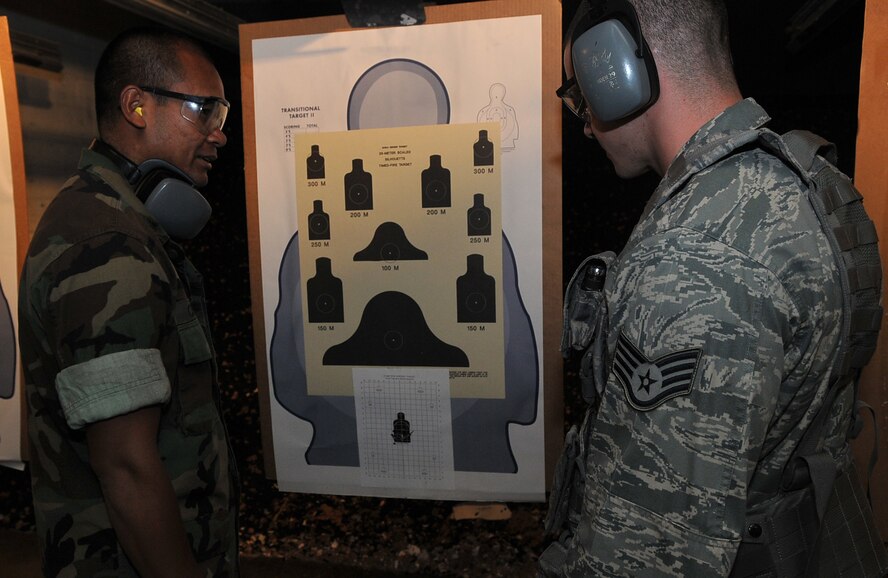 Gunners Mate 2nd Class Chamnol Cheng, small arms marksmanship instructor, speaks to Staff Sgt. Kevin Arndt, 11th Security Forces Squadron, about his target after firing Sept. 14 at the Anacostia Armory/Range on Anacostia. What used to be a firing range for only U.S. Navy members, now houses both the Navy and the Air Force. With joint basing rapidly approaching, the 11th Security Forces Squadron and the members at the Anacostia Armory/Range have already made the transition. (U.S. Air Force photo by Senior Airman Marleah Miller) 
