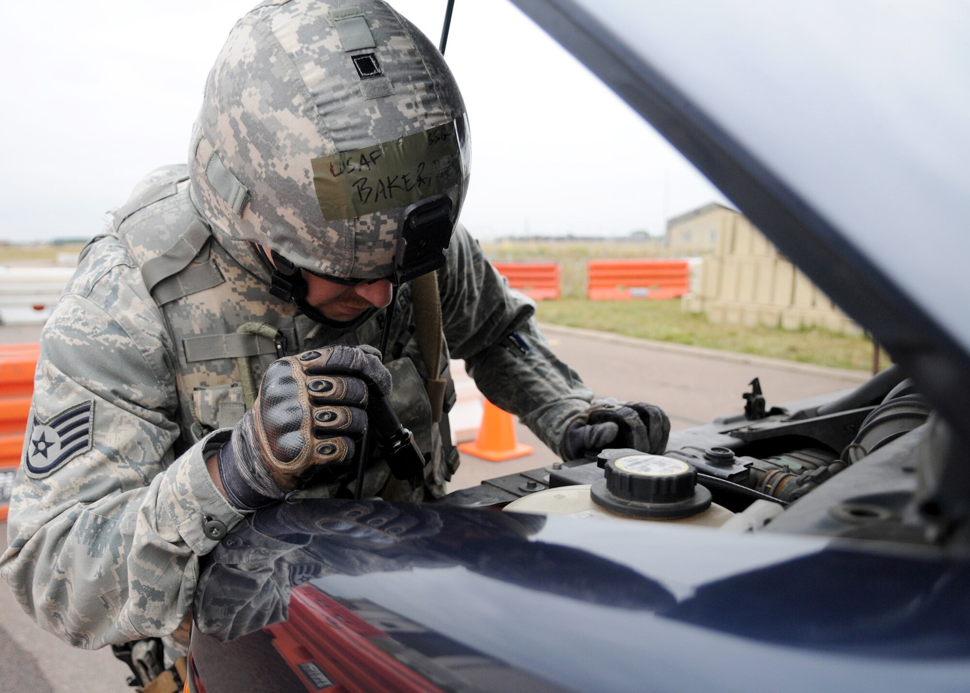 RAF MILDENHALL, England – Staff Sgt. Daniel Baker 100th Security Forces Squadron, looks around an engine bay during a vehicle inspection at the entry control point for the Operational Readiness Inspection Oct. 14. All vehicles entering “Base X” are thoroughly inspected for any unauthorized items. (U.S. Air Force photo/ Staff Sgt. Jerry Fleshman)