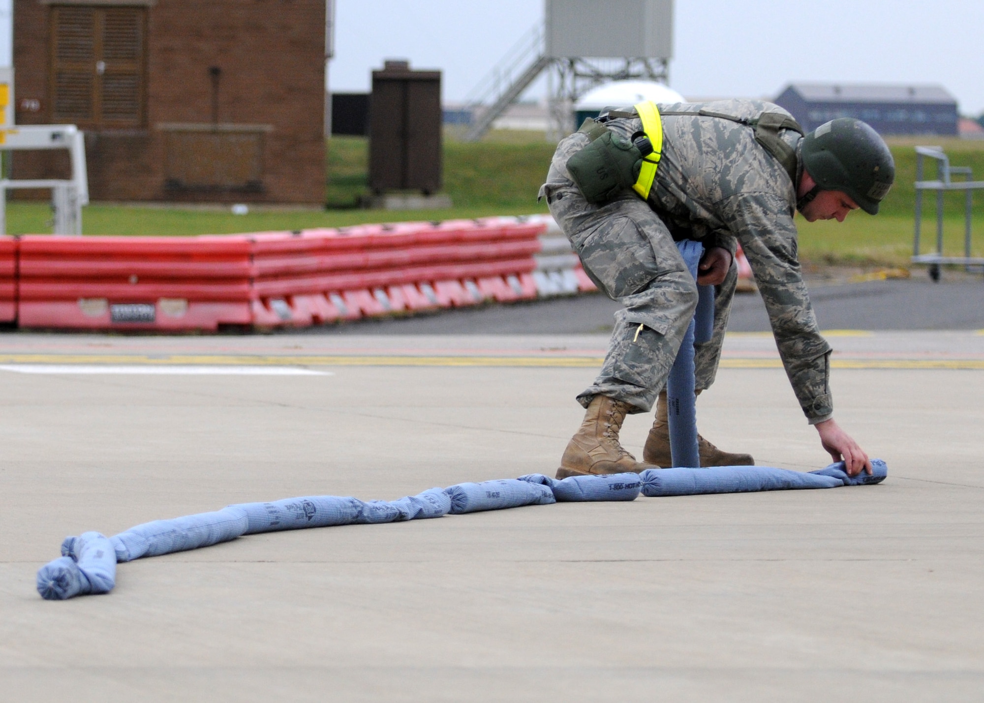 RAF MILDENHALL, England – Staff Sgt. Ryan LaVere, 100th Aircraft Maintenance Squadron crew chief, places absorbent containment barriers for the simulated aircraft fuel spill during the Operational Readiness Inspection Oct. 14. The ORI scenario tested the Airmen’s ability to effectively and safely react in an emergency situation. (U.S. Air Force photo/ Staff Sgt. Jerry Fleshman)
