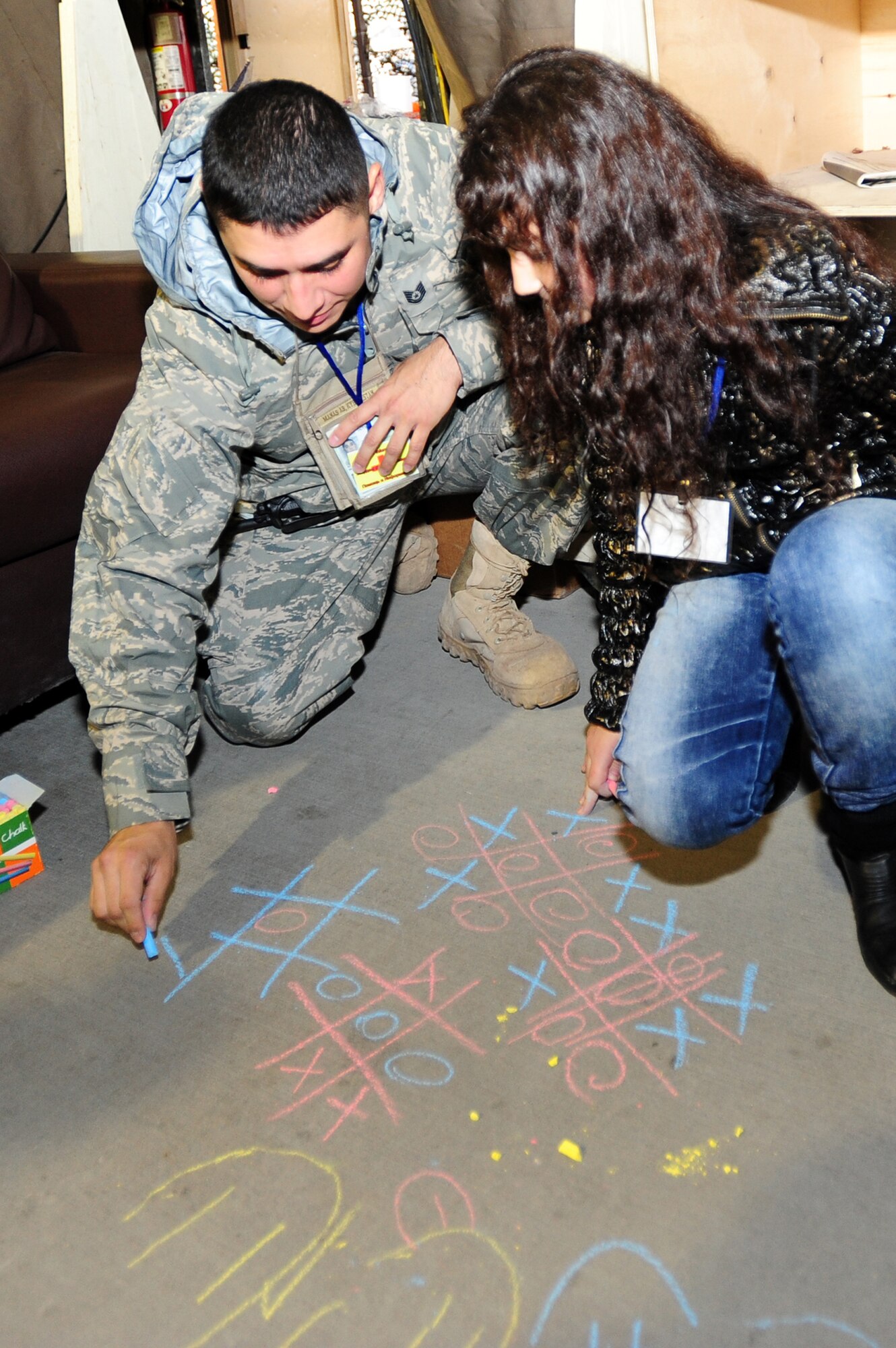 Tech. Sgt. Marcos Rodriguez plays tic-tac-toe with a Kyrgyz girl during Kyrgyz Friends and Family Day Oct. 9, 2009, at the Transit Center at Manas, Kyrgyzstan. The event strengthened friendships between the U.S. military and the local community. Sergeant Rodriguez is assigned to the 376th Expeditionary Security Forces Squadron. (U.S. Air Force photo/Senior Airman Steele C. G. Britton) 