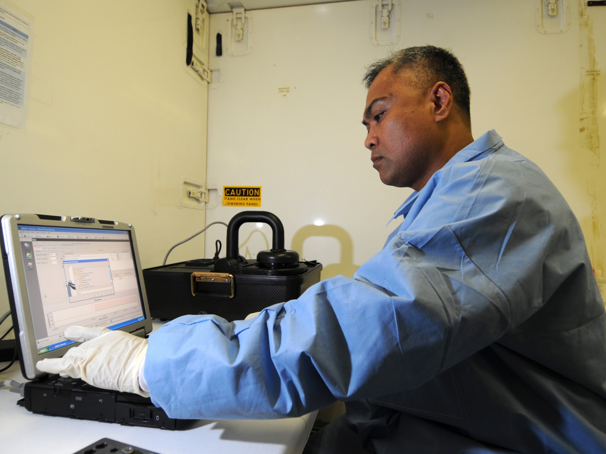 Maj. Lorenzo Gabiola, 379th Expeditionary Medical Group biological augmentation team chief, analyzes a sample, Oct. 13, 2009, using the base's new Joint Biological Agent Identification and Diagnostic System, which amplifies ribonucleic acid for H1N1 detection. Members of the 379 EMDG BAT team are the first Air Force personnel certified in detecting H1N1 using this technology. Major Gabiola is deployed from Tinker Air Force Base, Okla. in support of operations Iraqi Freedom and Enduring Freedom. (U.S. Air Force Photo/Tech Sgt. Jason W. Edwards)