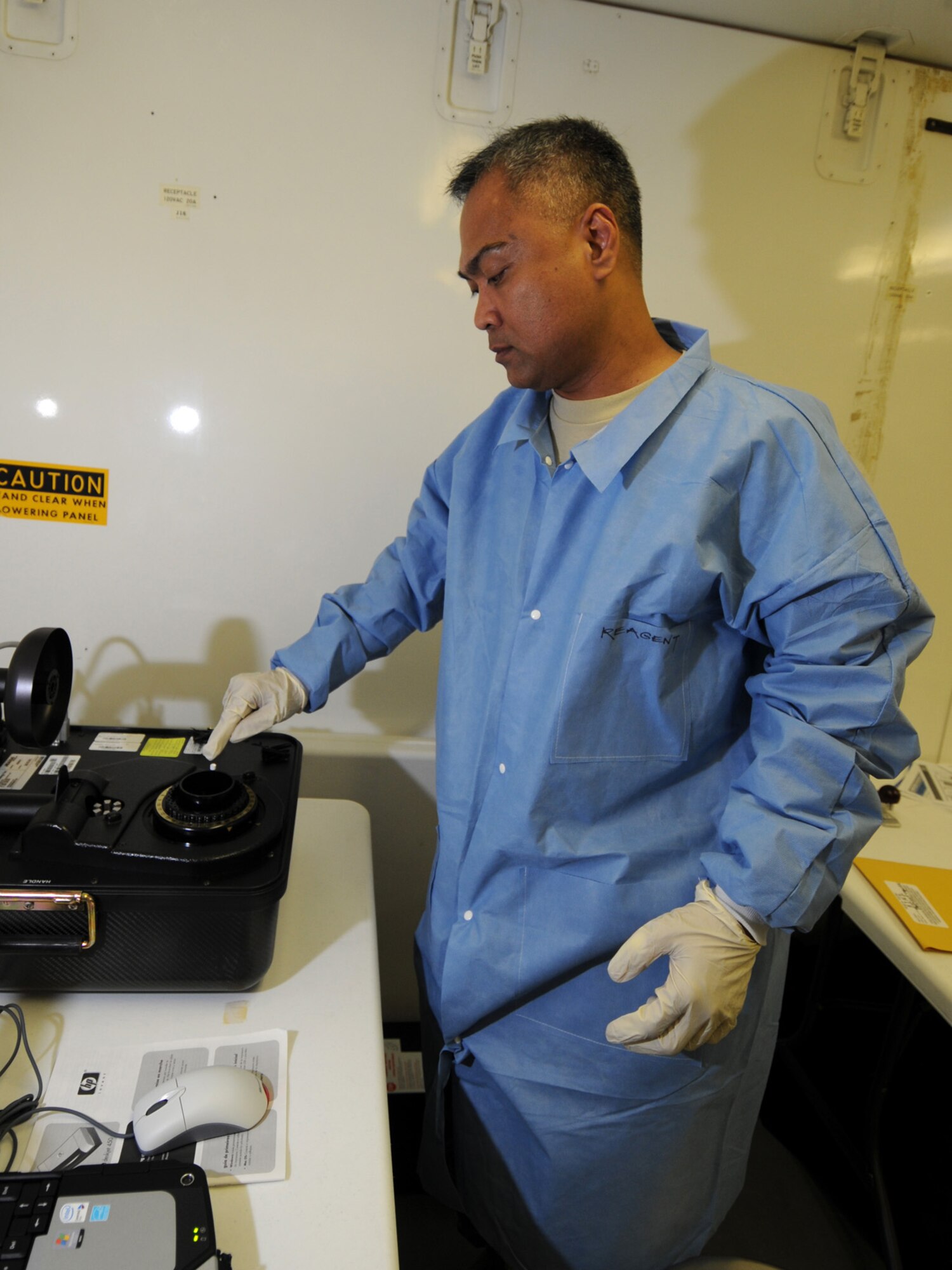 U.S. Air Force Maj. Lorenzo Gabiola, 379th Expeditionary Medical Group biological augmentation team chief, analyzes a sample, Oct. 13, 2009, using the base's new Joint Biological Agent Identification and Diagnostic System, which amplifies ribonucleic acid for H1N1 detection. Members of the 379 EMDG BAT team are the first Air Force personnel certified in detecting H1N1 using this technology. Major Gabiola is deployed from Tinker Air Force Base, Okla. in support of operations Iraqi Freedom and Enduring Freedom. (U.S. Air Force Photo/Tech Sgt. Jason W. Edwards)