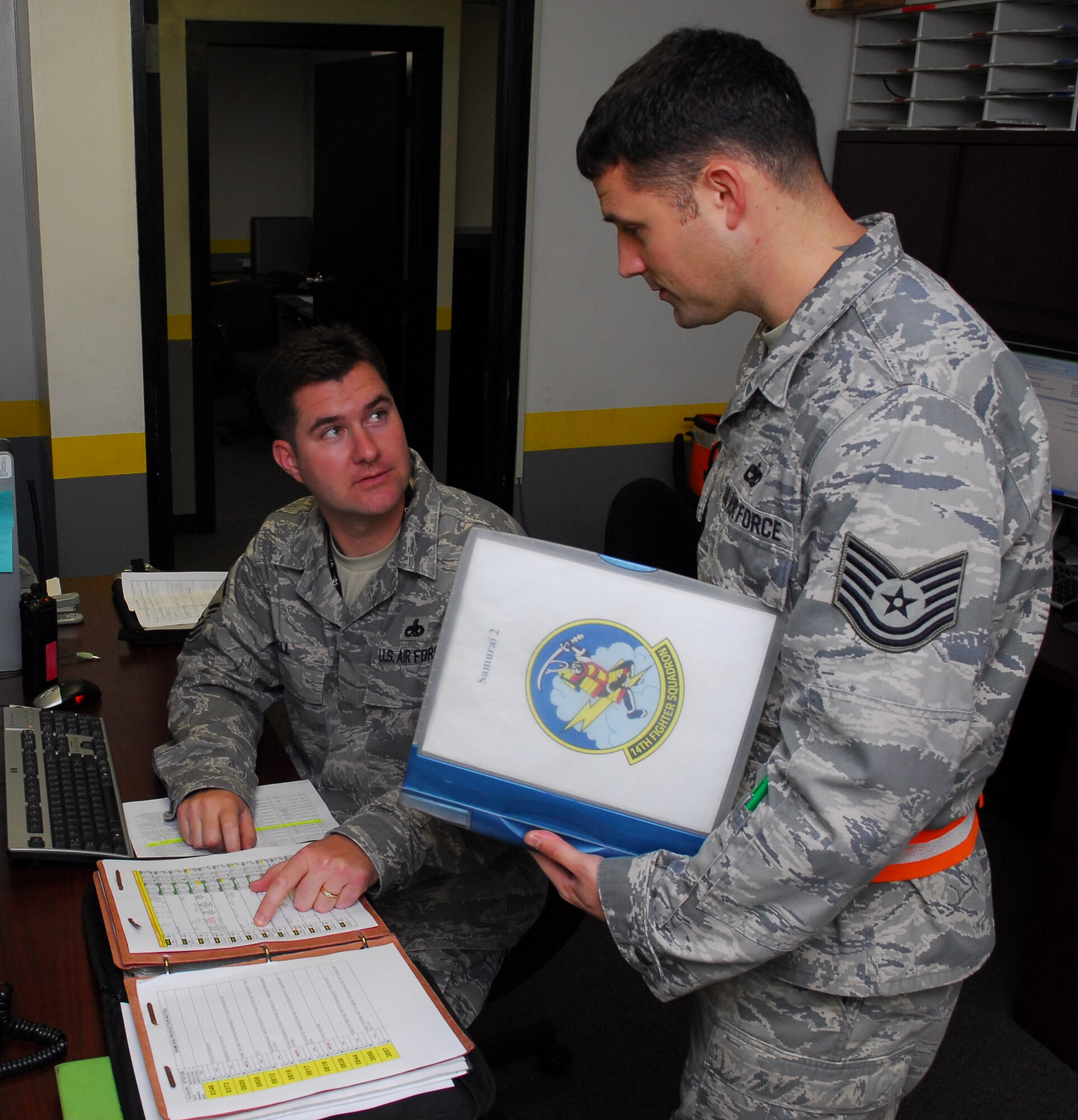 MISAWA AIR BASE, Japan -- Master Sgt. John Bell, 14th Aircraft Maintenance Unit production supervisor, shows Tech. Sgt. Douglas Frank, 14th AMU airframe power plant general expeditor, upcoming maintenance requirements for the shop Oct. 14 in the 14th AMU building. After the production supervisor receives updates from the 14th Fighter Squadron’s operations desk, the information is passed along to the expeditors. (U.S. Air Force photo/Staff Sgt. Phillip Butterfield)