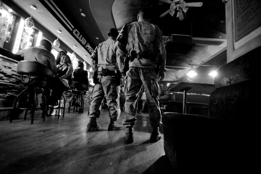 Two security forces Airmen conduct a walkthrough of a bar during their nightly patrol of Songtan Entertainment District outside Osan Air Base, Republic of Korea. Town Patrol is a volunteer position for the Security Forces Airmen here. Teams work together in different areas every night. Their job consists of force protection, blocking traffic within the walking areas and patrols of the many bars, restaurants and off limit areas. While traveling through the streets to each of the facilities, they stay aware of everyone and everything with the primary goal of ensuring safety. ( U.S. Air Force photo/ Senior Airman Stephenie Wade)